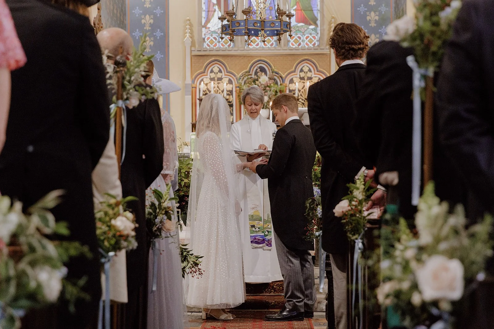 bride and groom surrounded by wedding flowers at Lee Bay church in North Devon