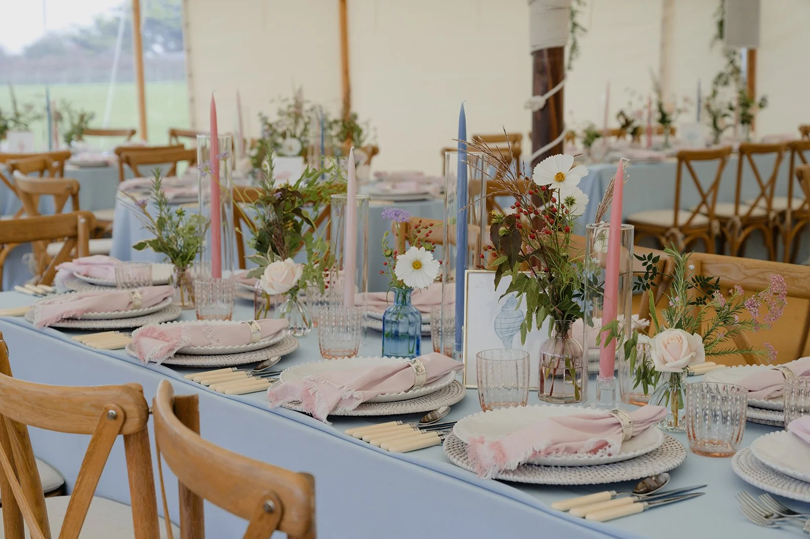 bud vases full of natural and seasonal flowers on long banquet tables for marquee wedding
