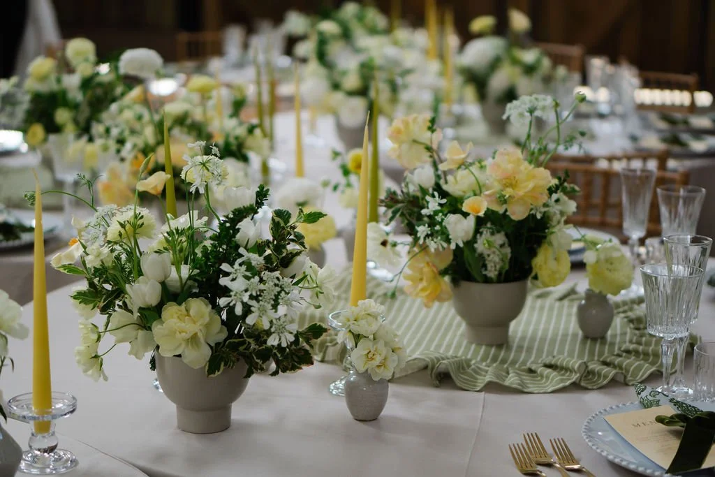 natural and elegant butter yellow table flower decorations in ceramic bowls on long banquet tables
