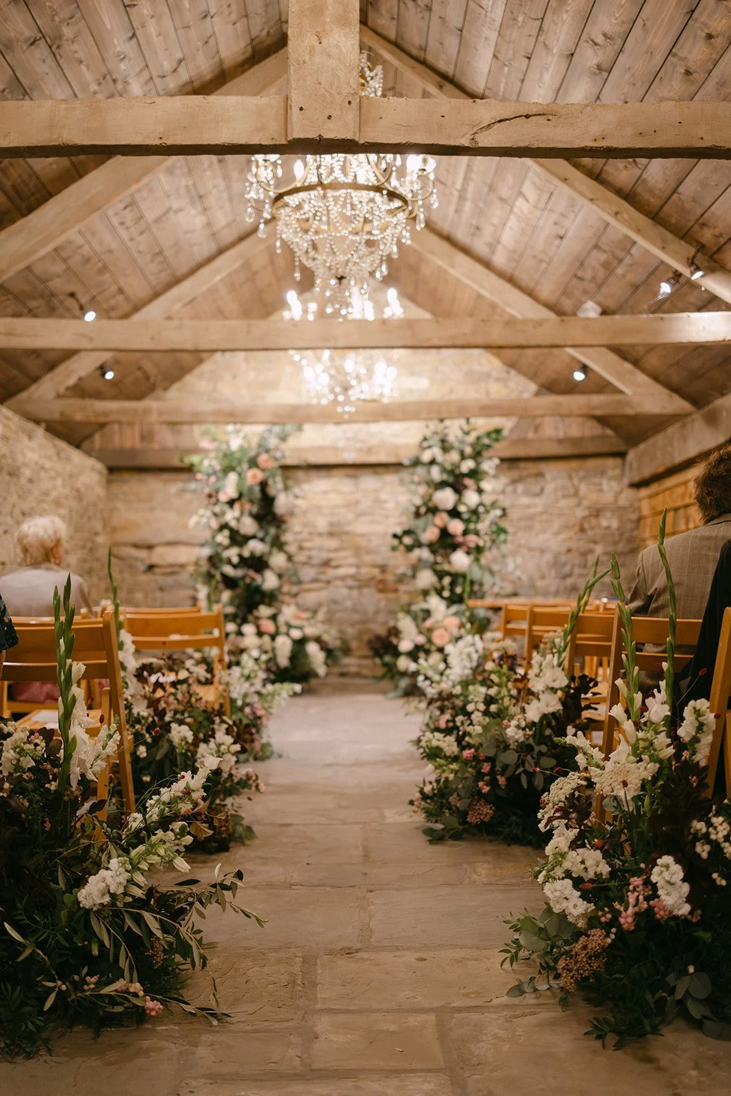 ivory, blush and burgundy meadow flower aisle and natural broken flower arch at ceremony at Kingston Estate