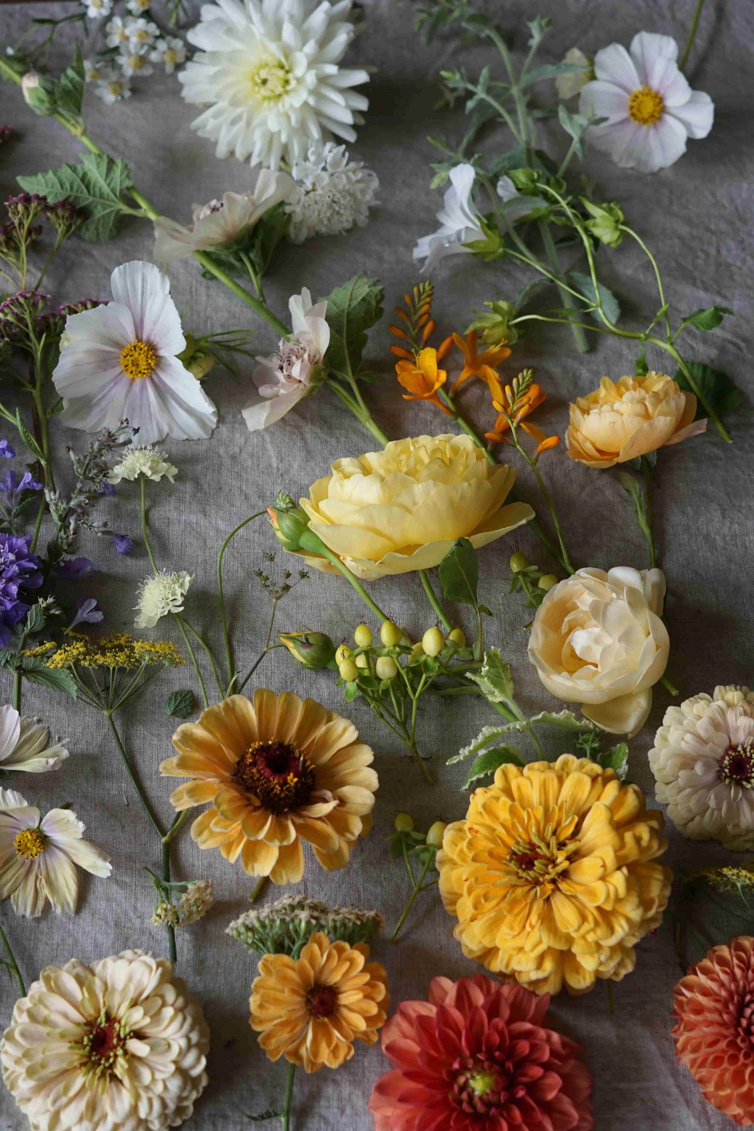 British flower flat lay of wedding flowers in white, orange, yellow and coral