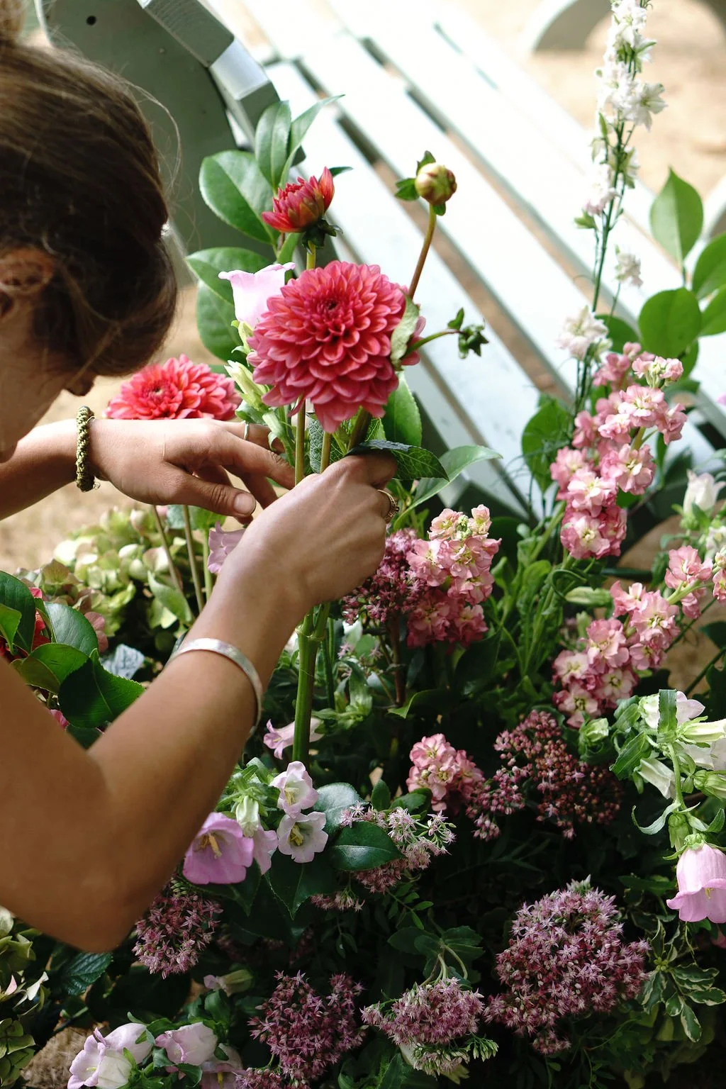 Devon florist creating summer meadow flower arrangements for outdoor wedding at Huntsham Court