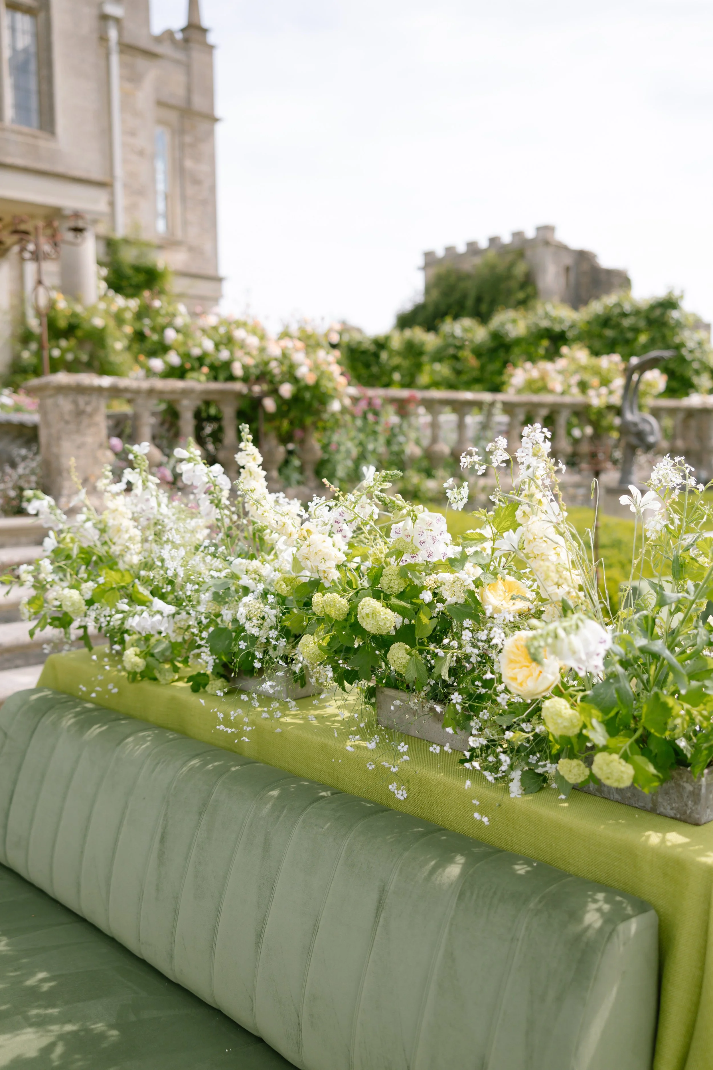Butter yellow meadow flowers on lounge seating outside Euridge Manor gardens for drink reception