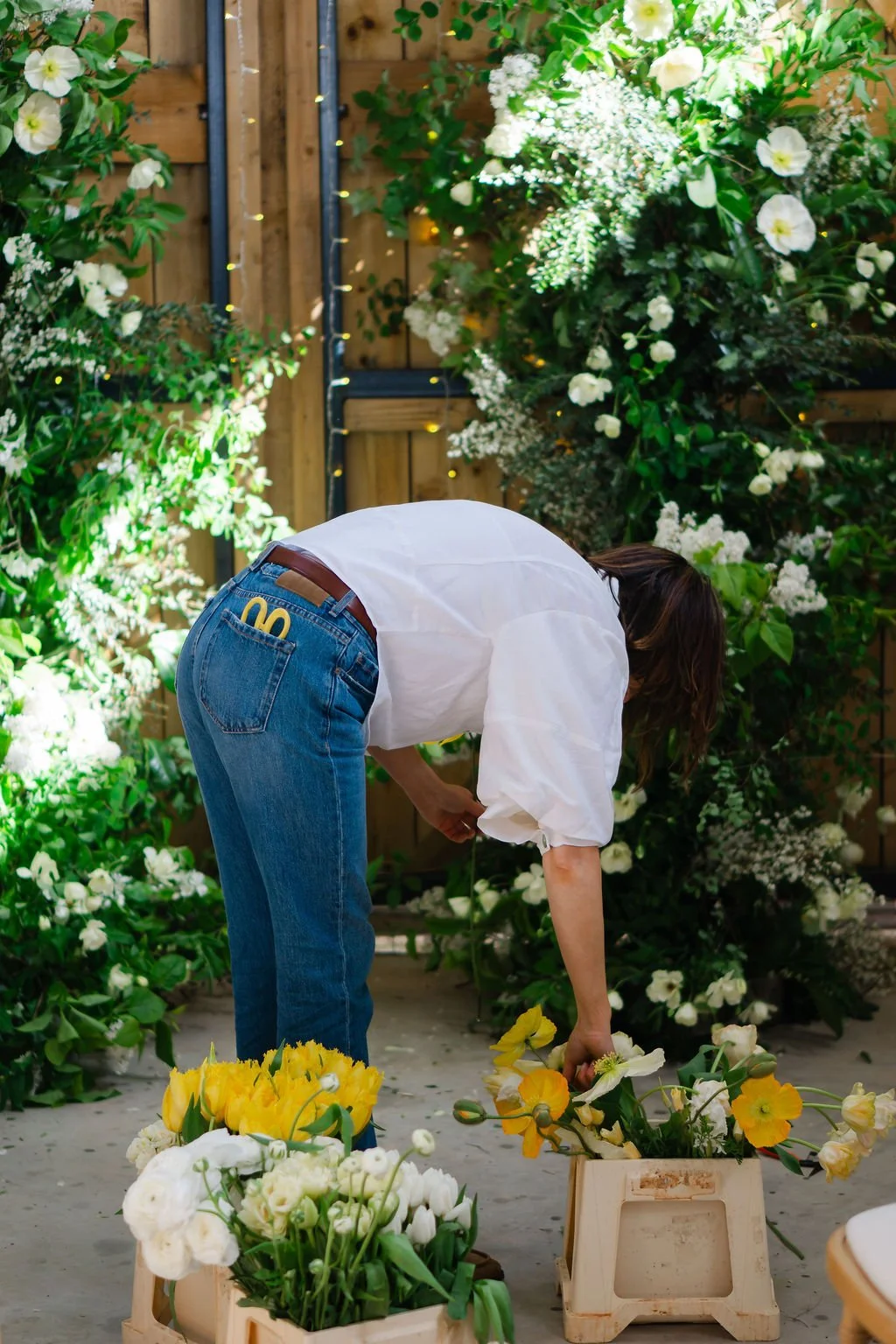 wedding florist picking flowers out of dutch buckets, creating a broken flower arch at a Somerset barn venue