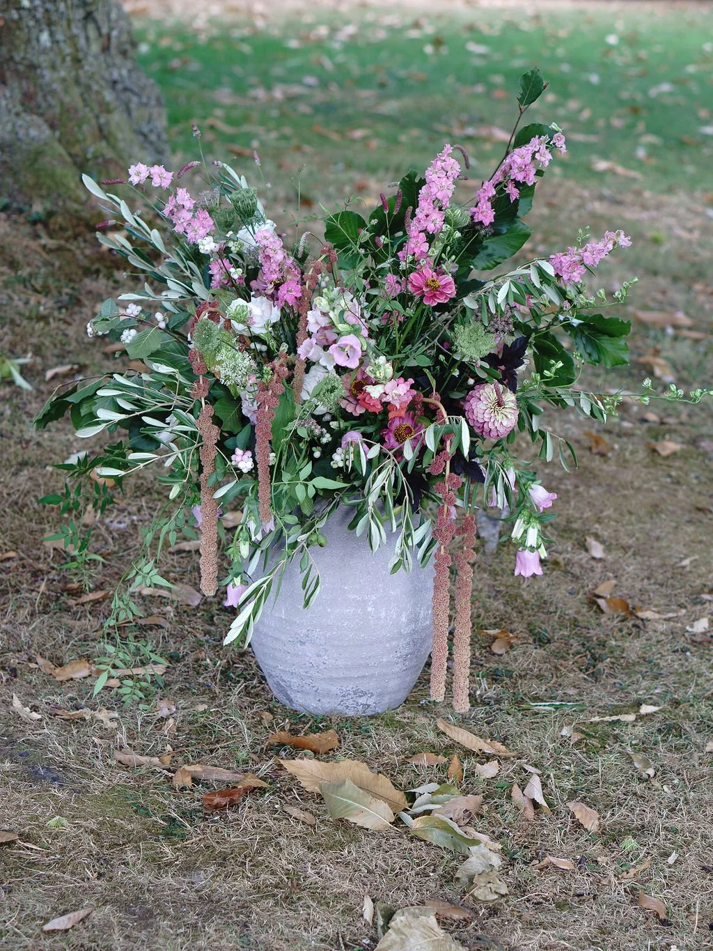 stylish and natural seasonal wedding ceremony flowers in stone vase for outdoor wedding ceremony