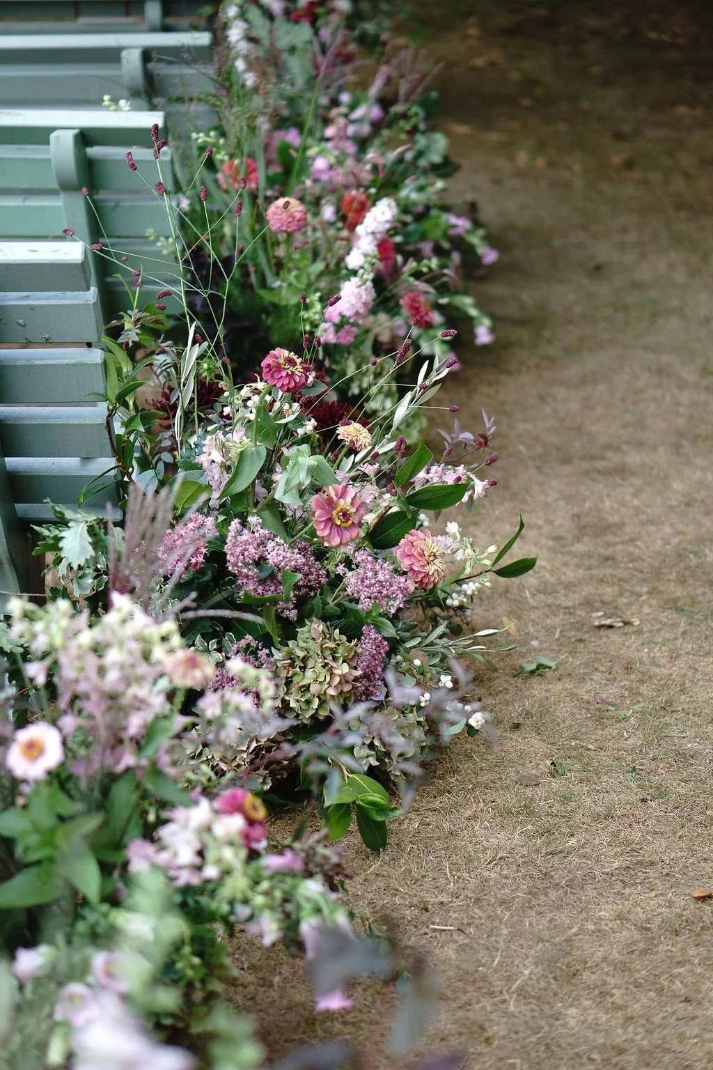 full, natural, elegant and seasonal meadow flower aisle in deep dusky pink and muted green tones