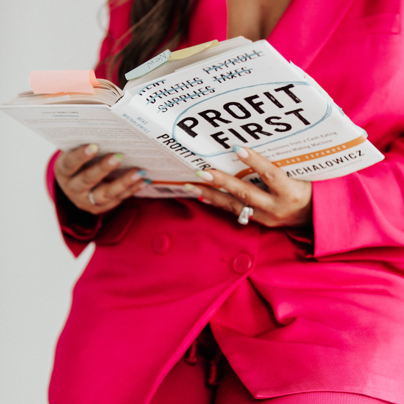 Lou Clarke reading Profit First wearing a hot pink suit