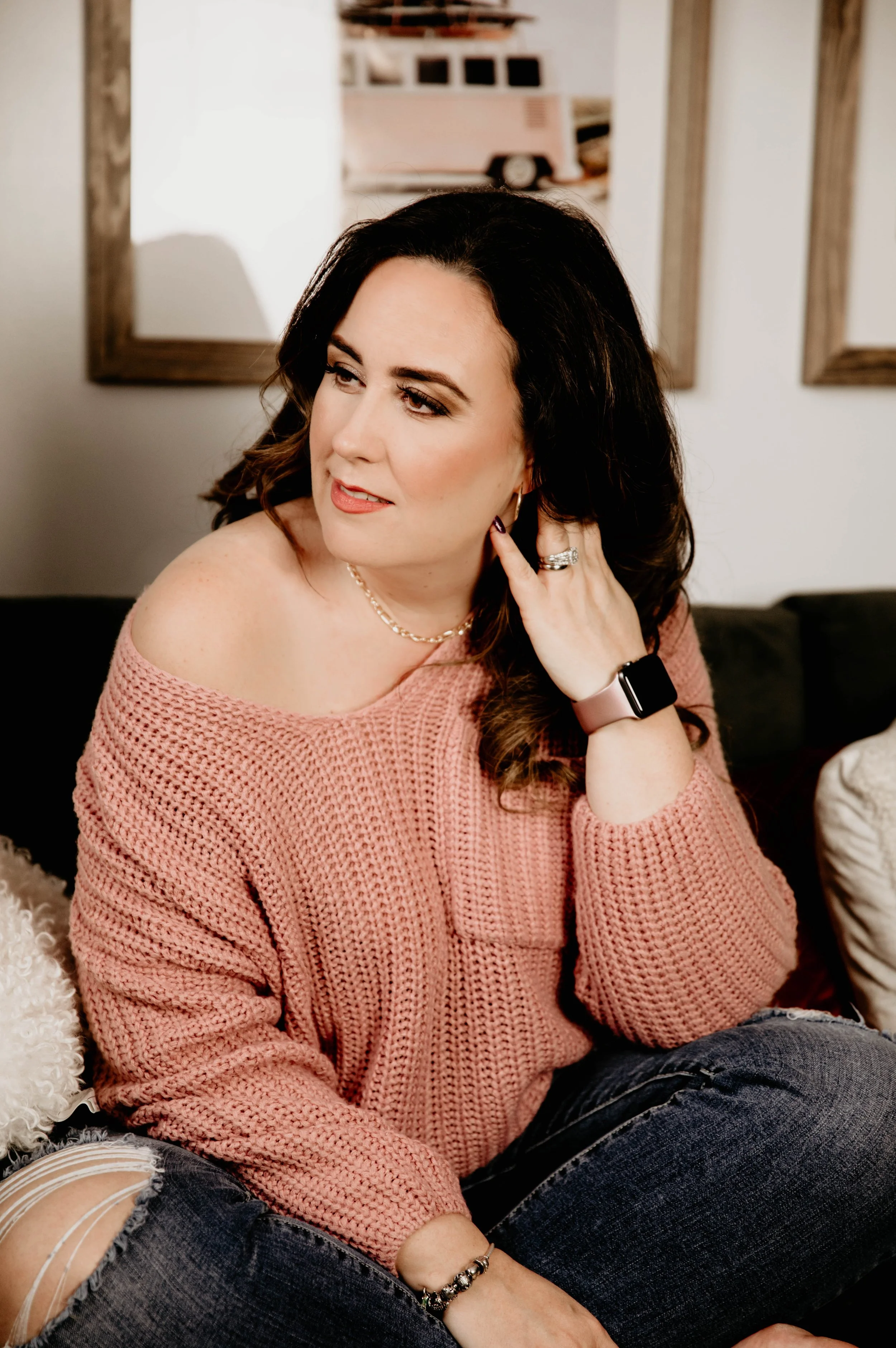 Lou Clarke sitting on a couch, wearing a pink sweater.