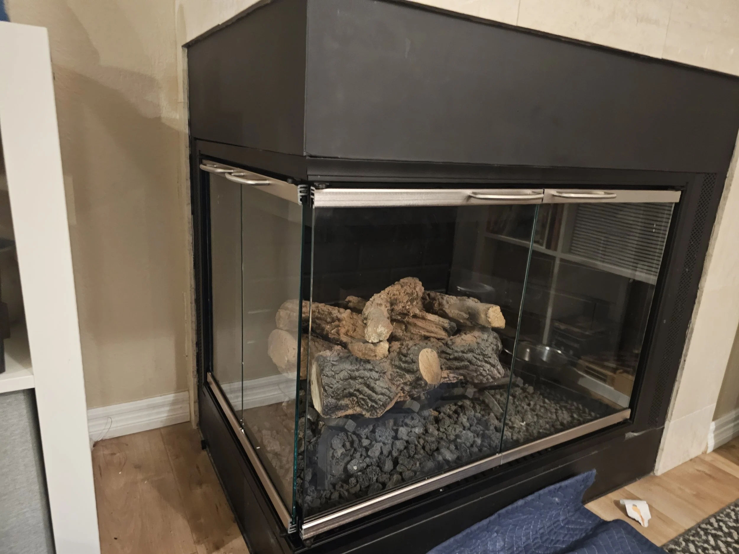 Gas fireplace with glass doors and rocks inside.
