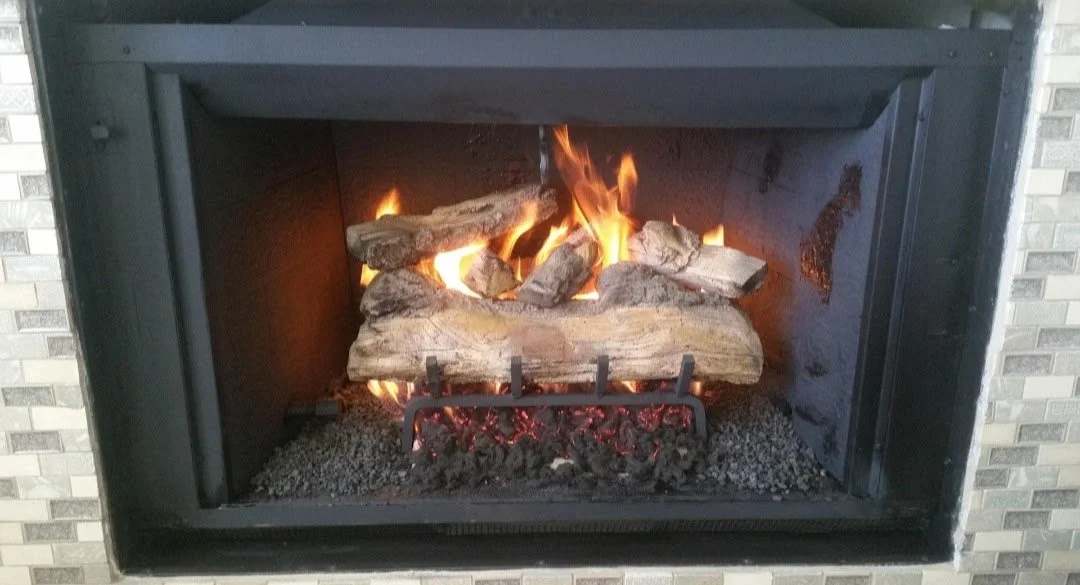 Fireplace with burning logs and flames inside.