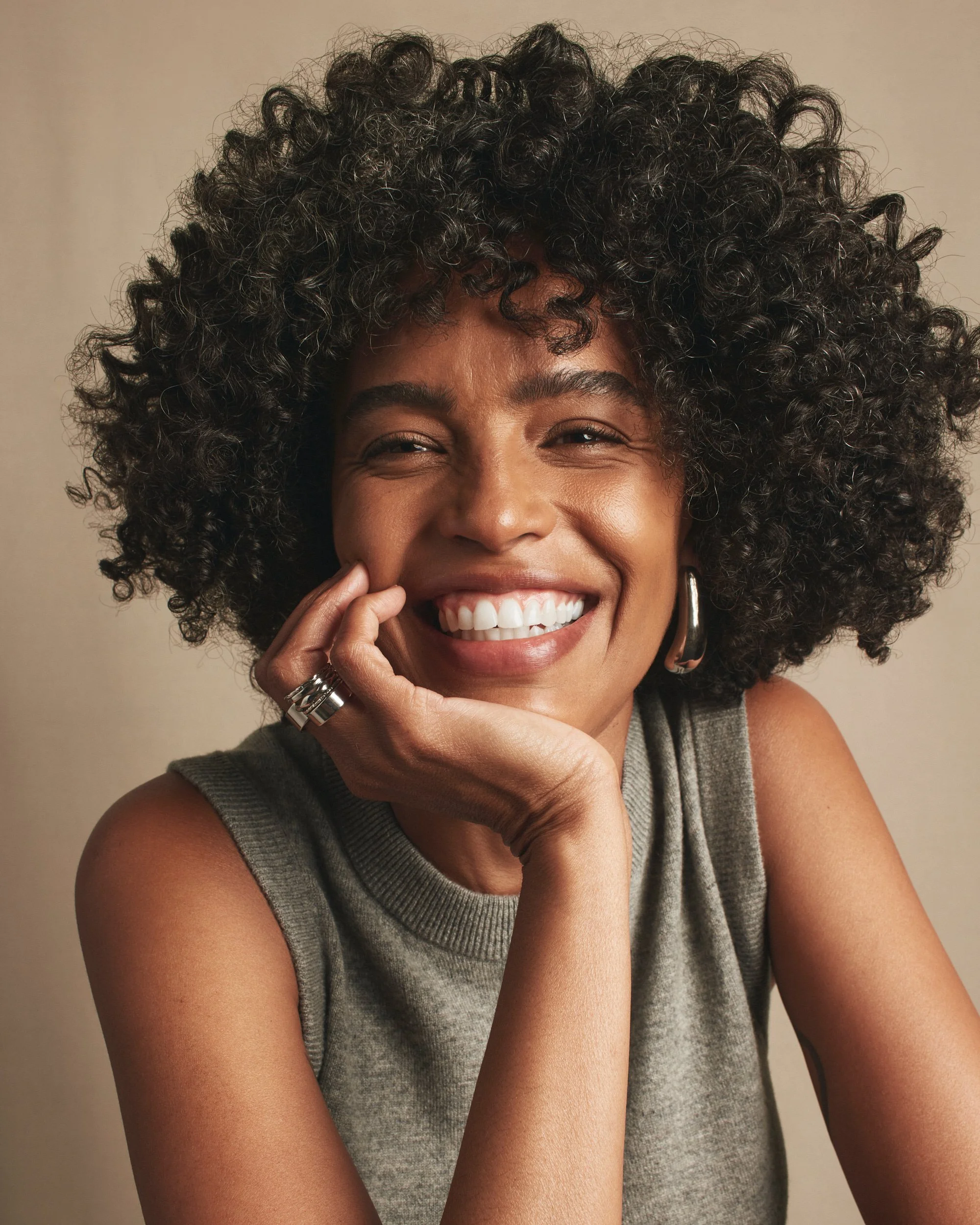 Joshua Pestka commercial beauty photography — Mary Kay TimeWise Repair campaign, model with natural curly hair smiling, hand on chin