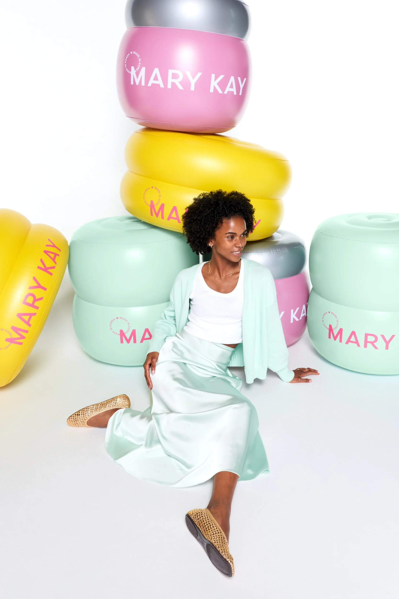 joshua-pestka-mary-kay-k-beauty-curly-hair-model-seated-among-inflatable-jars.jpg