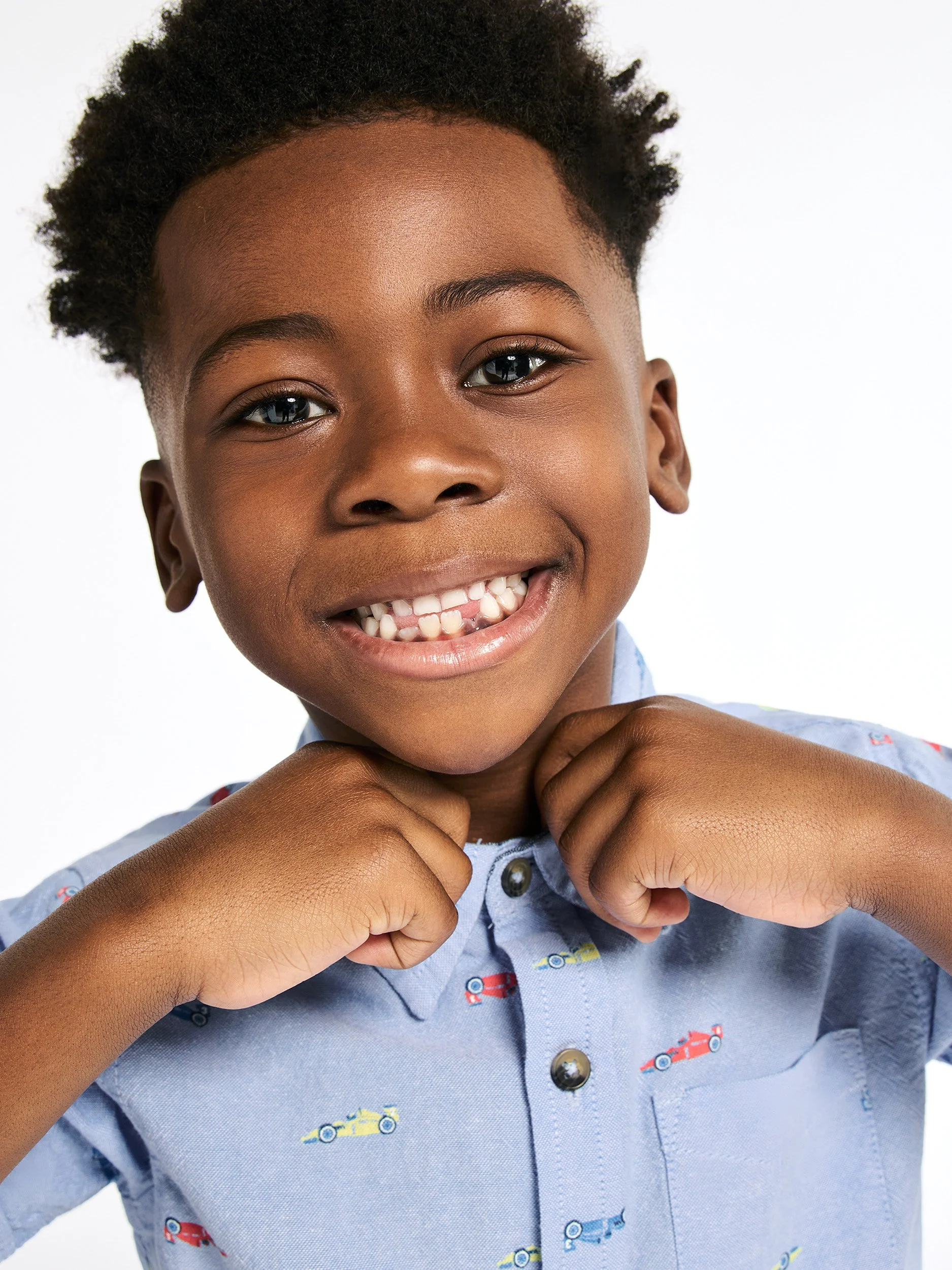 Joshua Pestka kids fashion photography — boy in blue button-down shirt, buttoning buttons