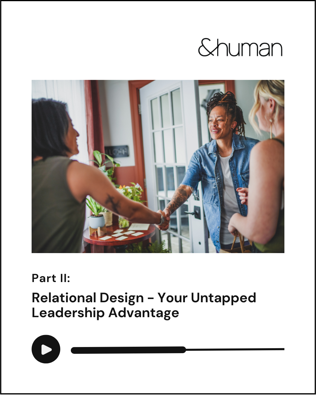 A woman in a denim jacket shaking hands with another woman with two other women nearby, in a cozy interior with plants and a table, during a social or professional meeting.