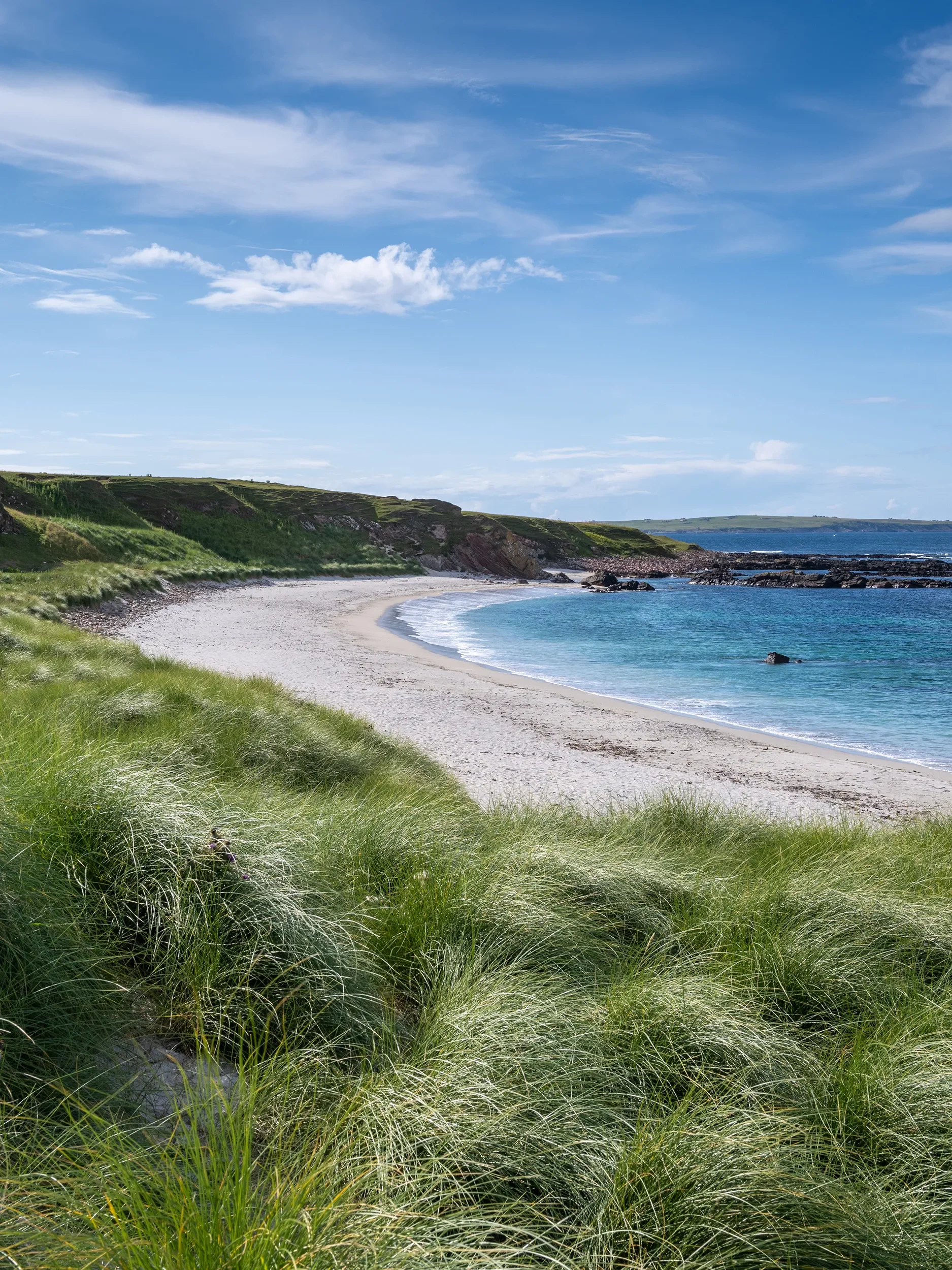 A tall, illuminated steel tower structure seen through a foggy atmosphere, with train tracks leading toward it at night.