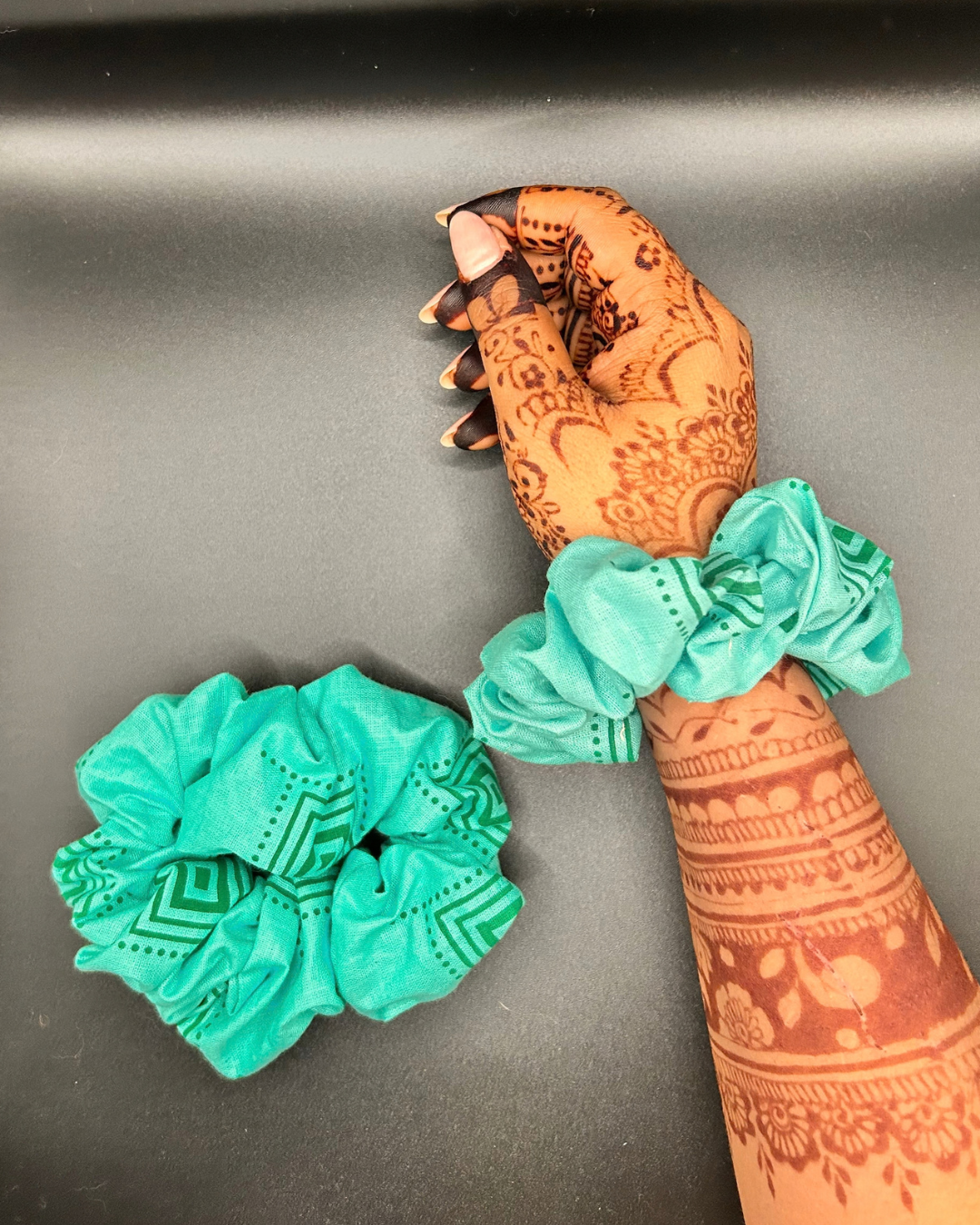 Turquoise fabric scrunchie with green geometric pattern