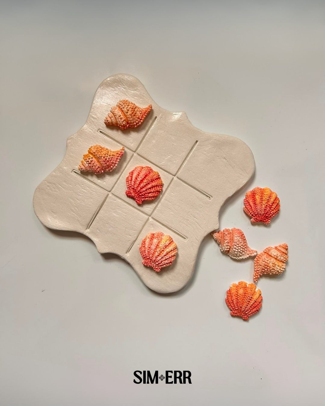 Pearl white handmade Tic Tac Toe board by Sim.err shown with customizable seashell playing pieces
