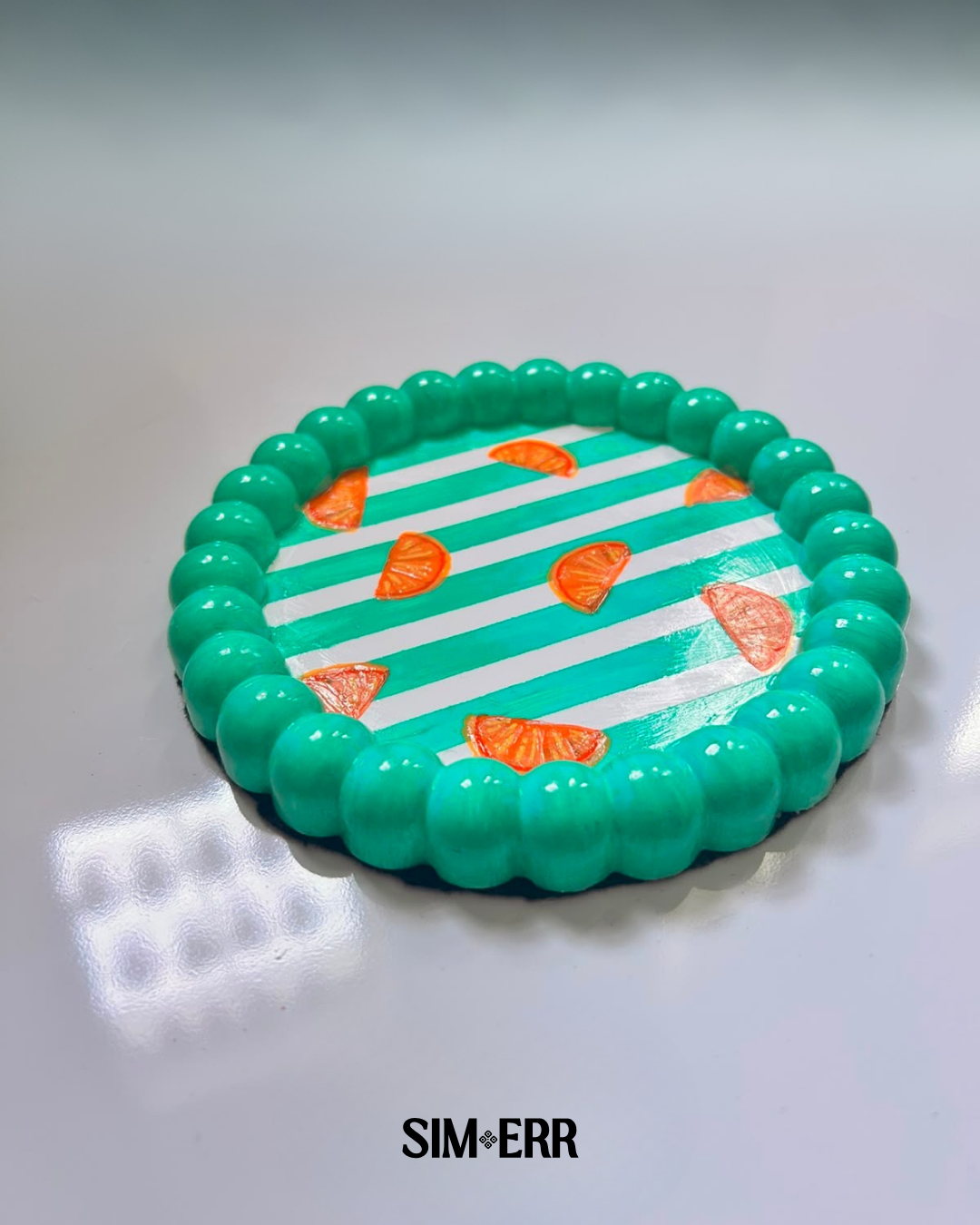 Handmade teal striped bubble tray with hand-painted orange slices by Sim.err side view