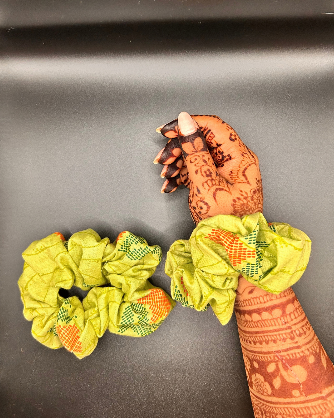 Yellow-green printed scrunchie with orange and green decorative motifs