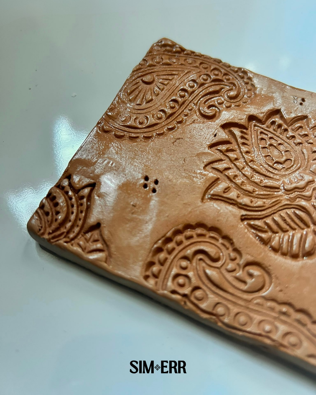 Handmade terracotta 4-inch coaster embossed with lotus and paisley patterns by Sim.err