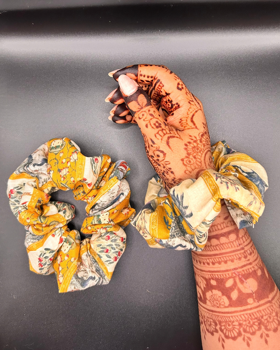 Cream and mustard floral fabric scrunchie worn on wrist
