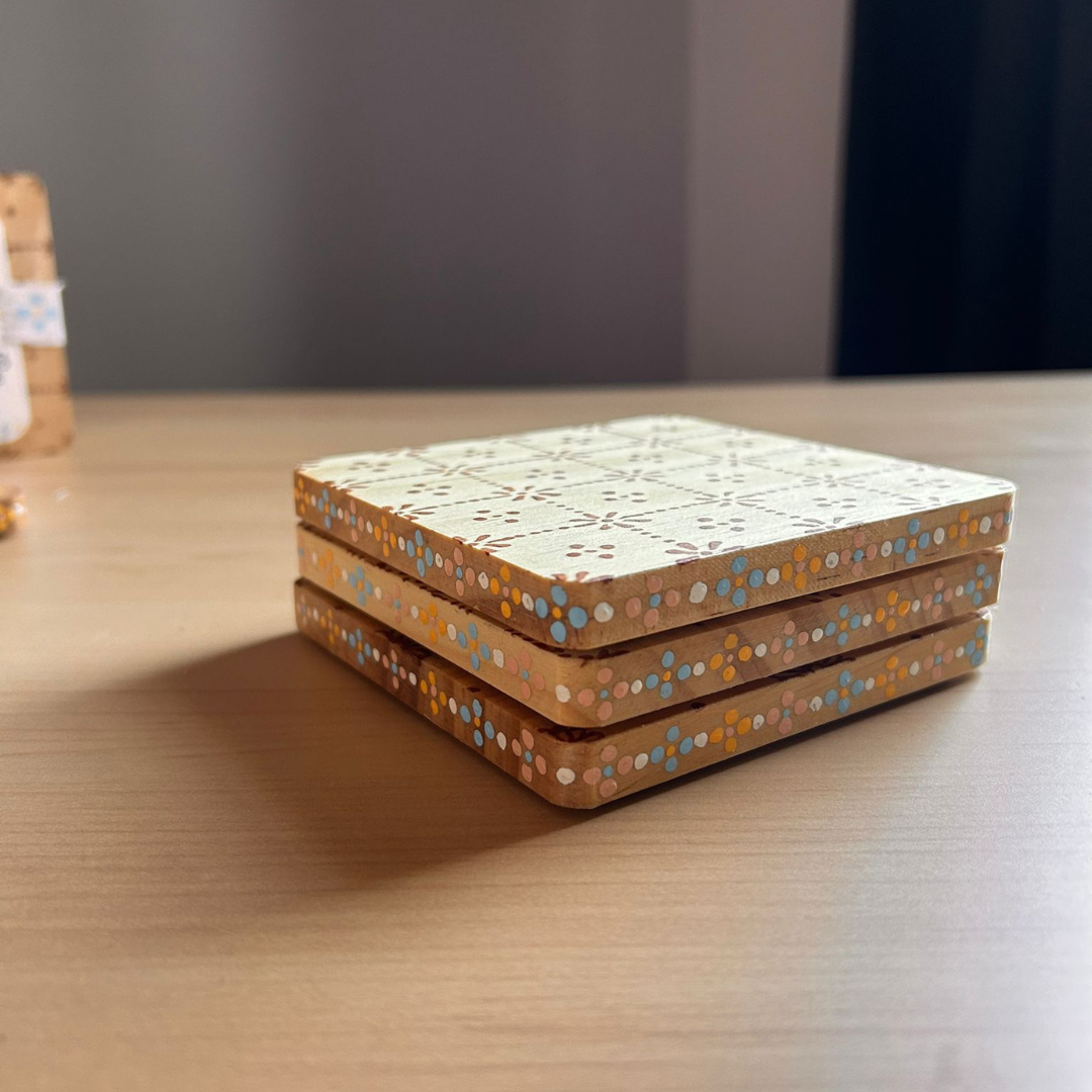 Side view of set of 3 henna stained coasters with colourful dot pattern.png