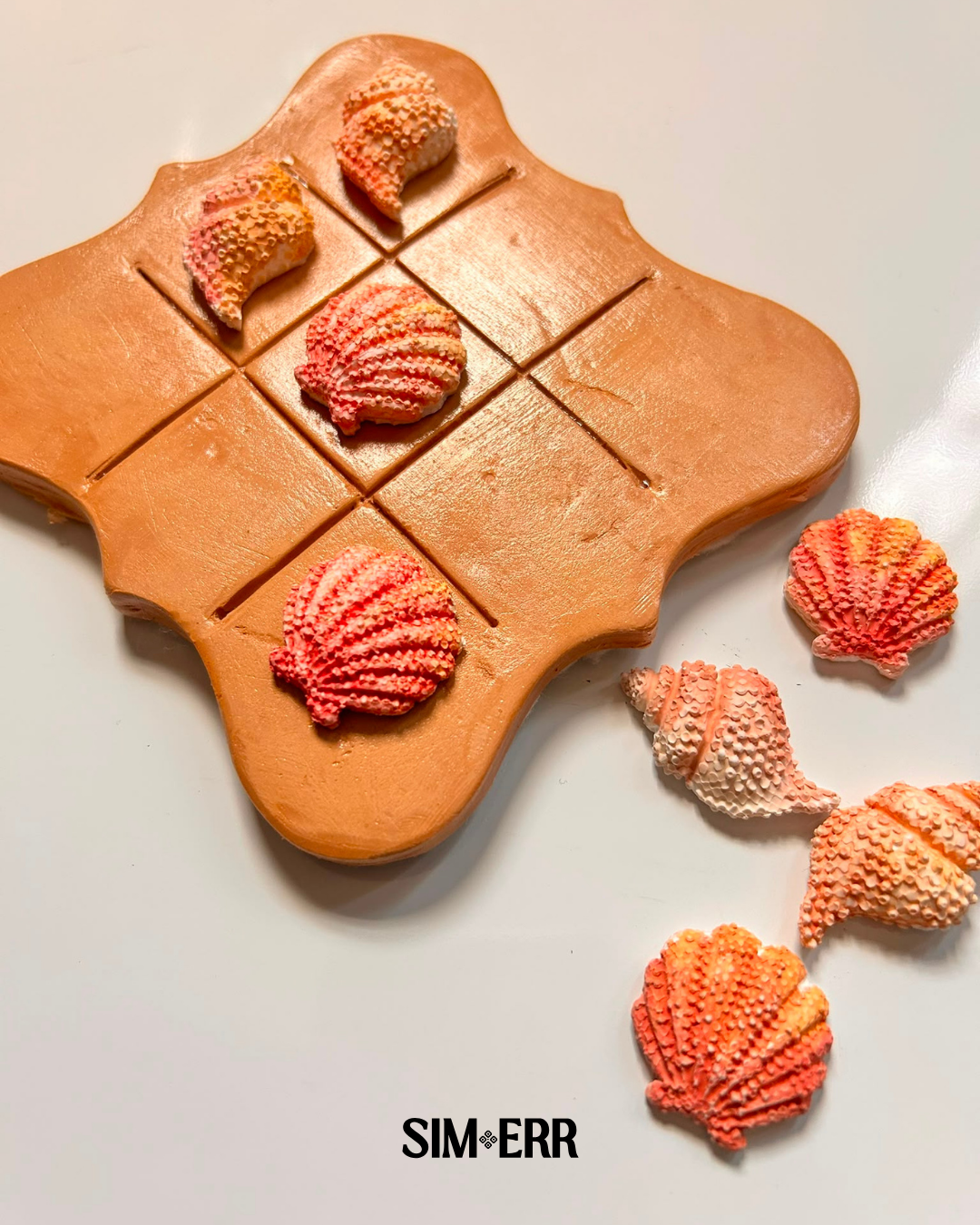 Handmade terracotta Tic Tac Toe board by Sim.err shown with customizable cookie and waffle playing pieces