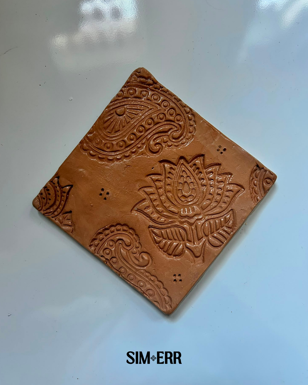 Handmade terracotta 4-inch coaster embossed with lotus and paisley patterns by Sim.err