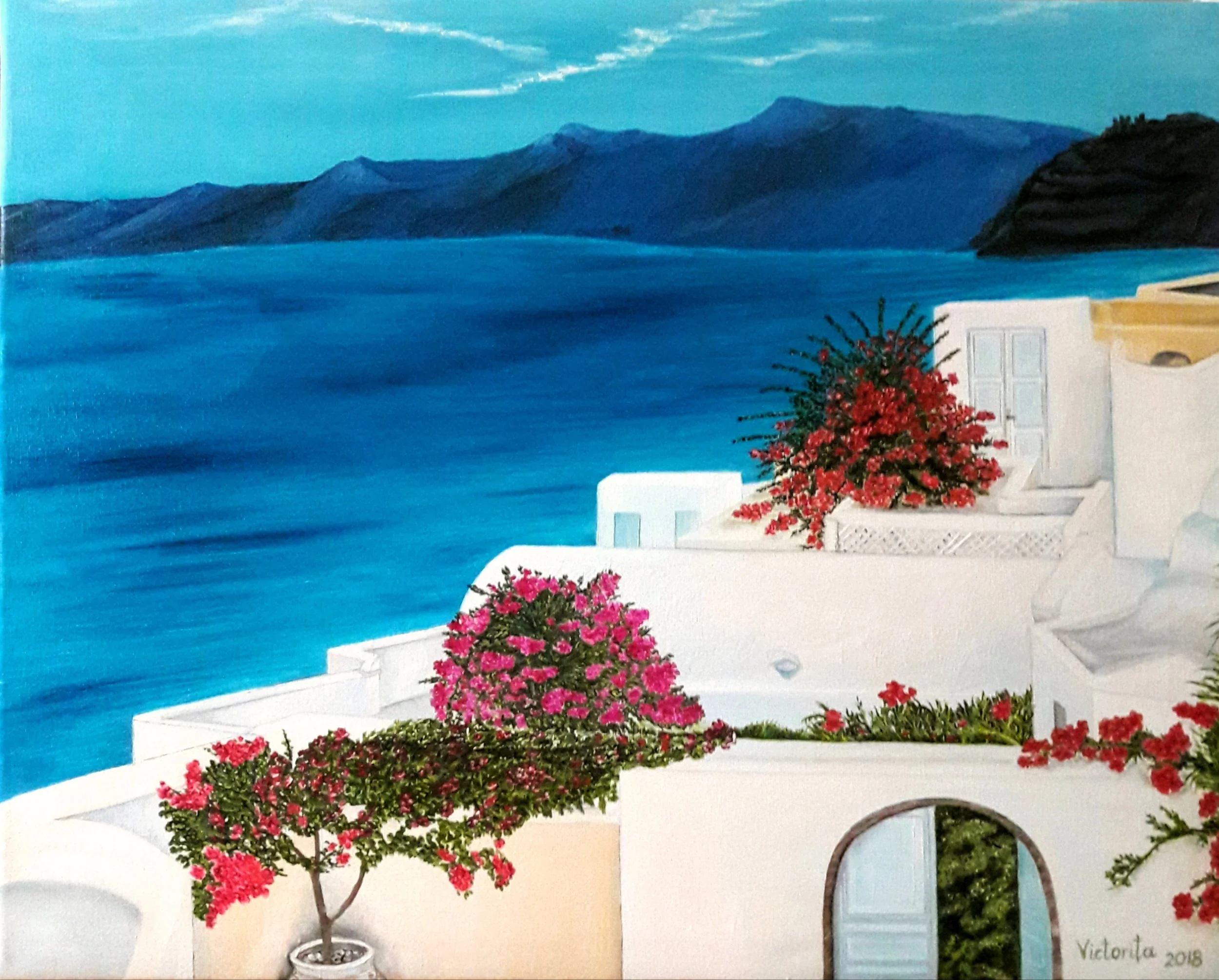 A painting depicting a seaside scene with a white building, decorated with vibrant red and pink flowers, against a backdrop of calm blue water, a mountainside, and a clear sky, signed 'Victoria 2018'.