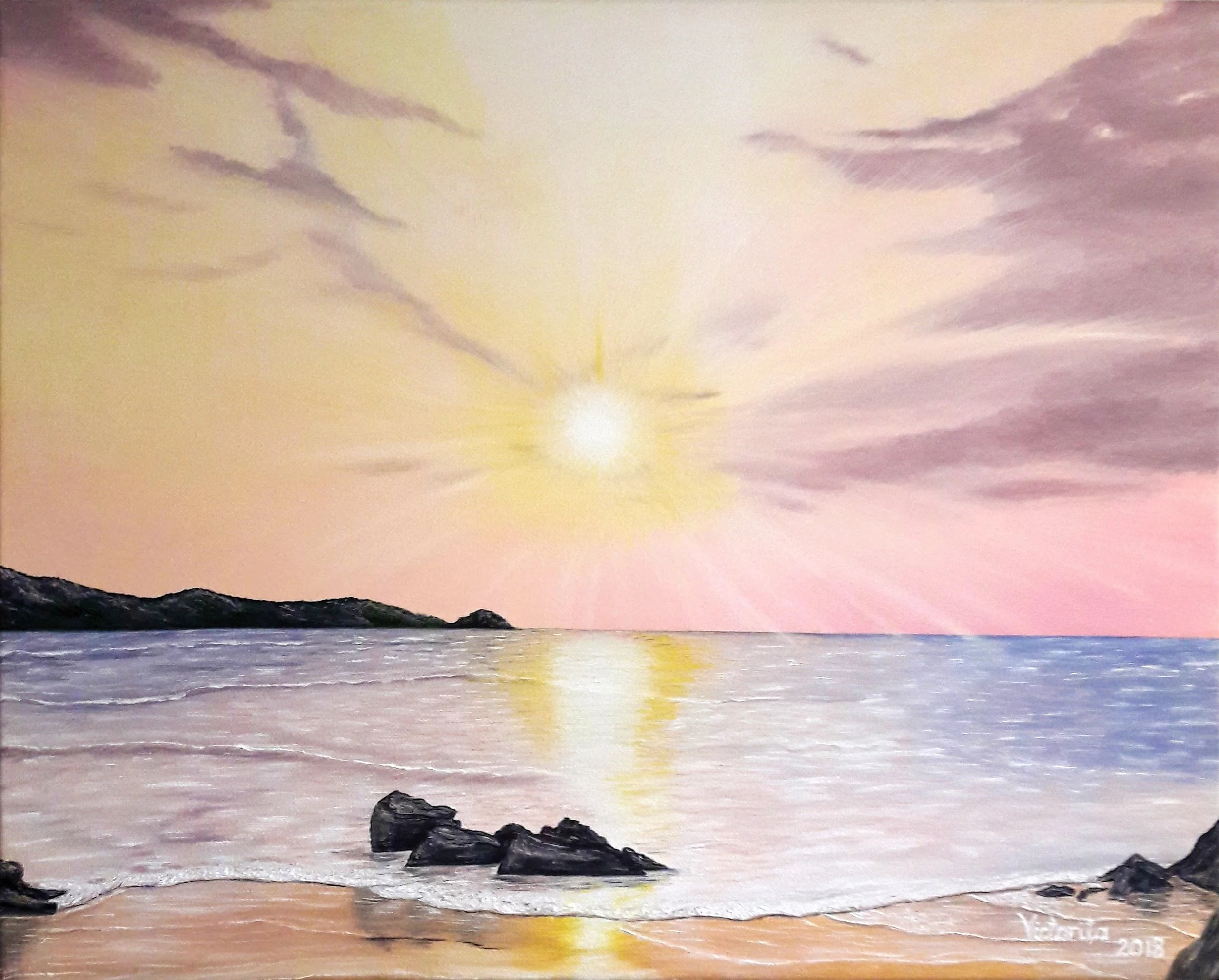 A sunset over a body of water with dark rocks in the foreground and rosy sky in the distance. The sky is partly cloudy with the sun visible on the horizon.