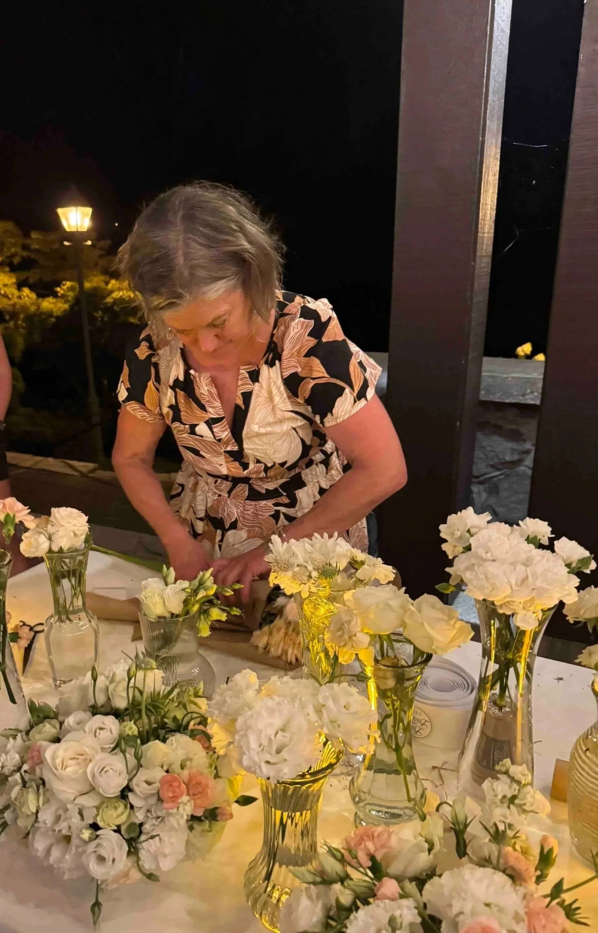 Anne at table with many flowers in vases
