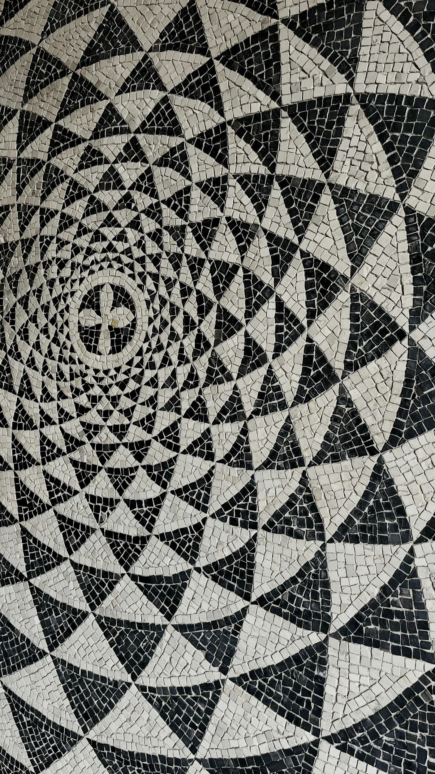 A black and white spiraling pattern of mosaic tile