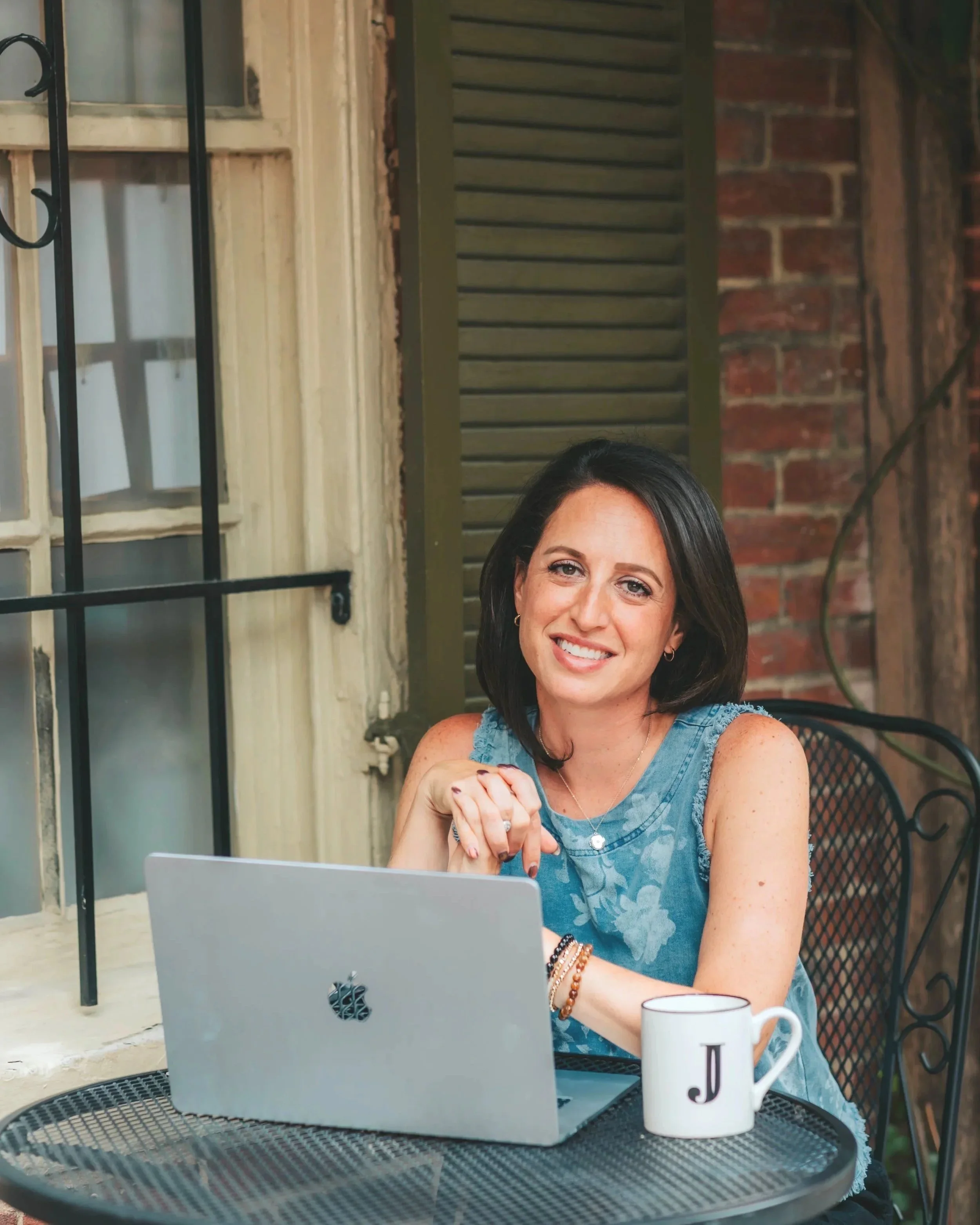 Jacqueline Laurenzi, couples therapist, working on laptop outdoors in Virginia