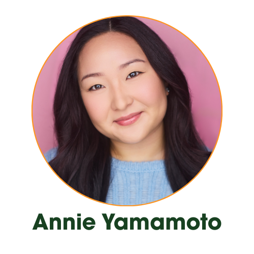 A young woman with long dark hair, smiling and winking, wearing a blue sweater against a pink background.