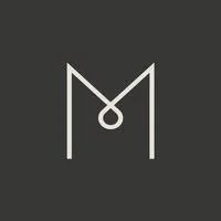 En minimalistisk logotyp med en stiliserad bokstav M och en cirkel ovanför, på svart bakgrund.