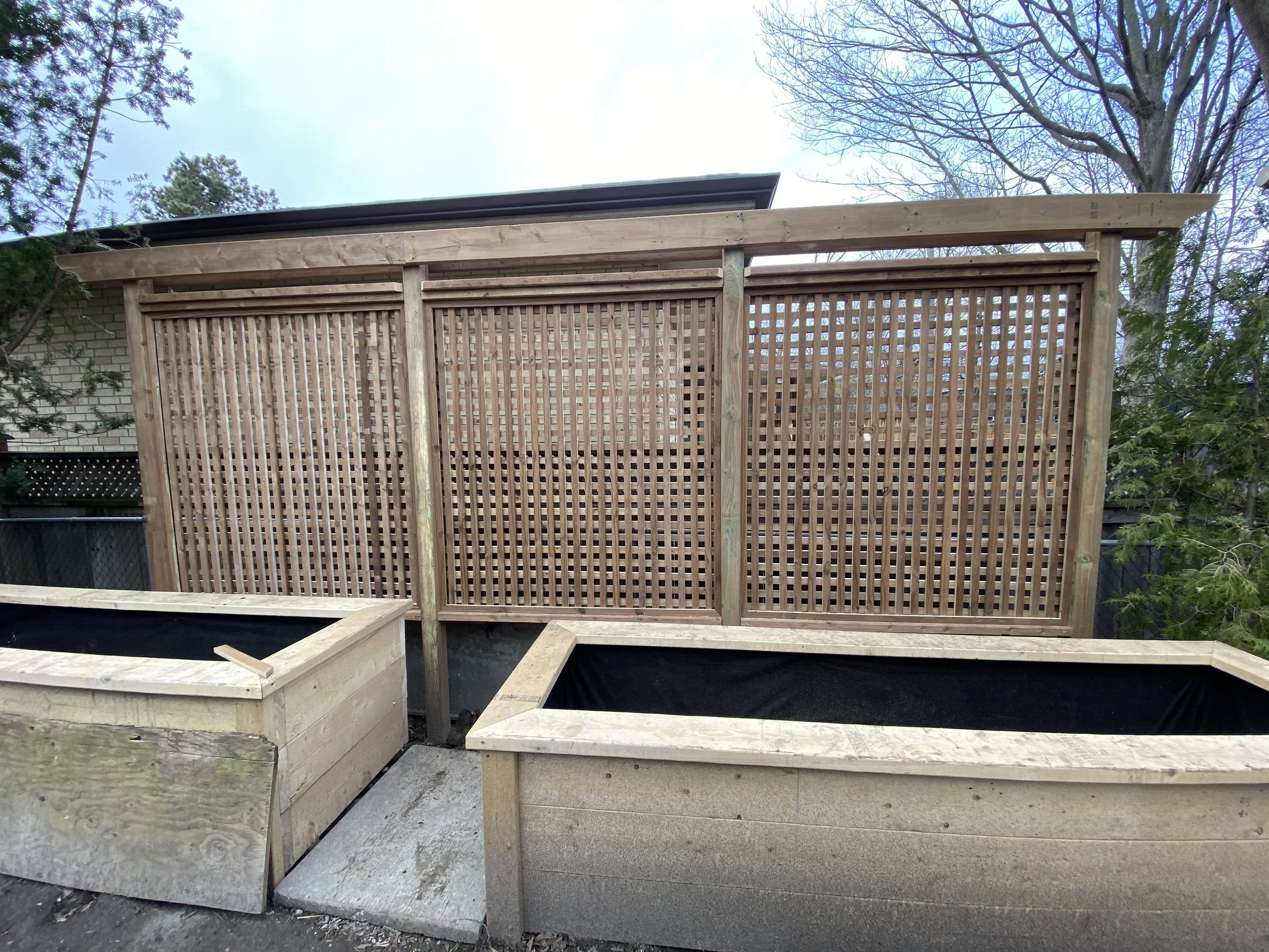 New wooden garden fencing with planters in front