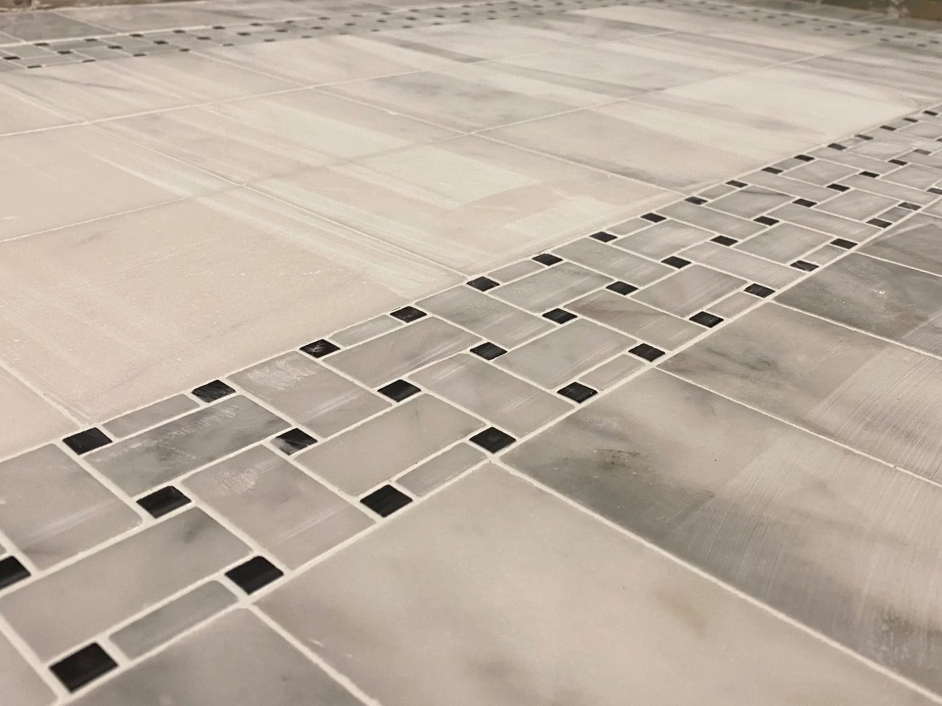 Close-up of tile flooring with a decorative stripe pattern.