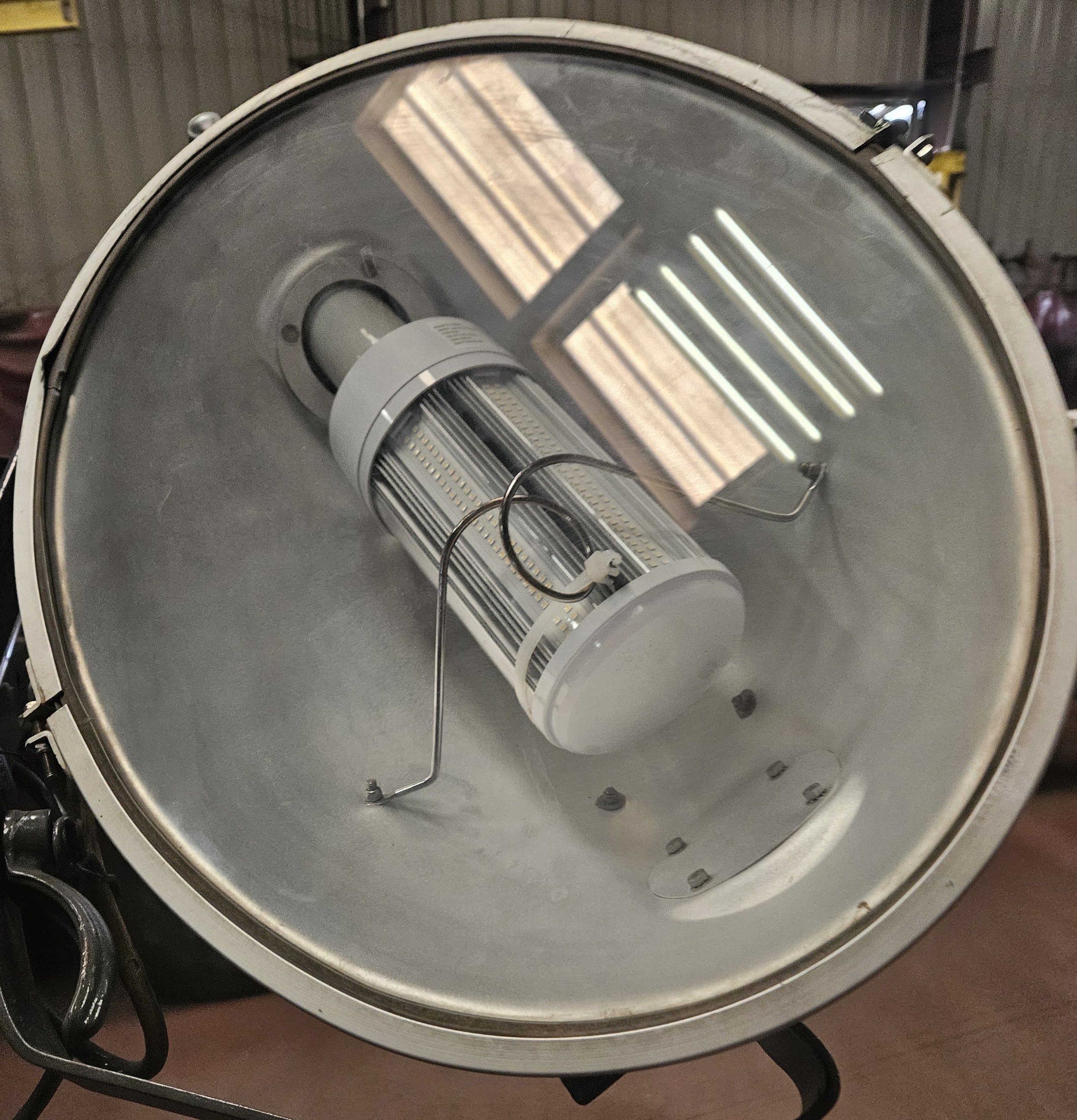 A close-up view of a commercial LED grow light with a reflective hood.