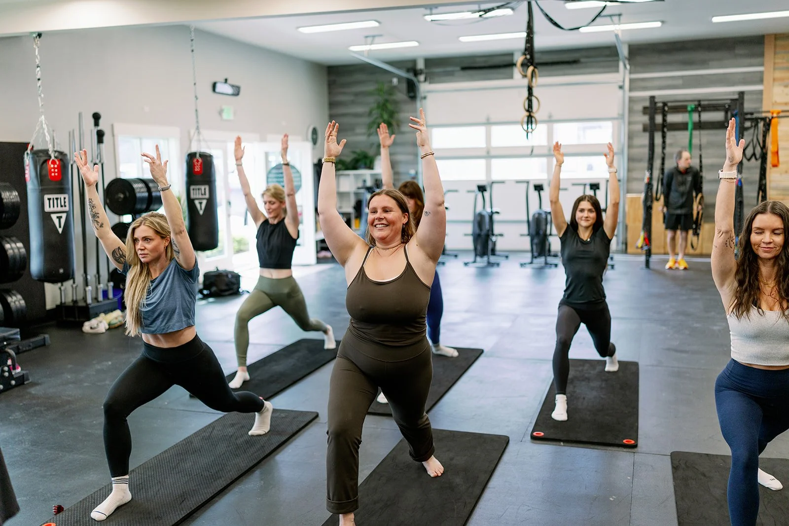 Women participating in a group yoga class performing Cobra pose on mats in a fitness studio.