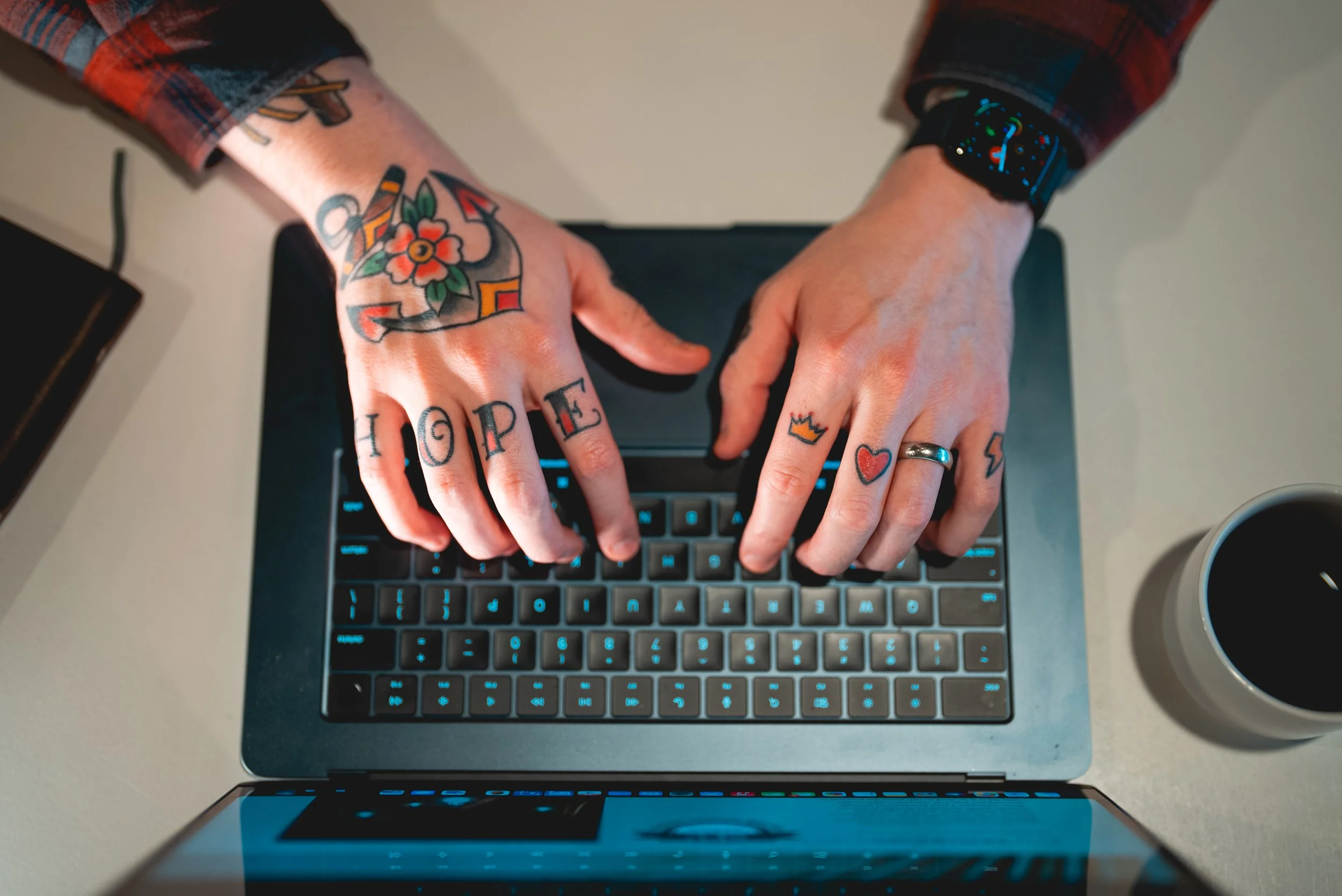 Close-up of Chris' hands working with his laptop