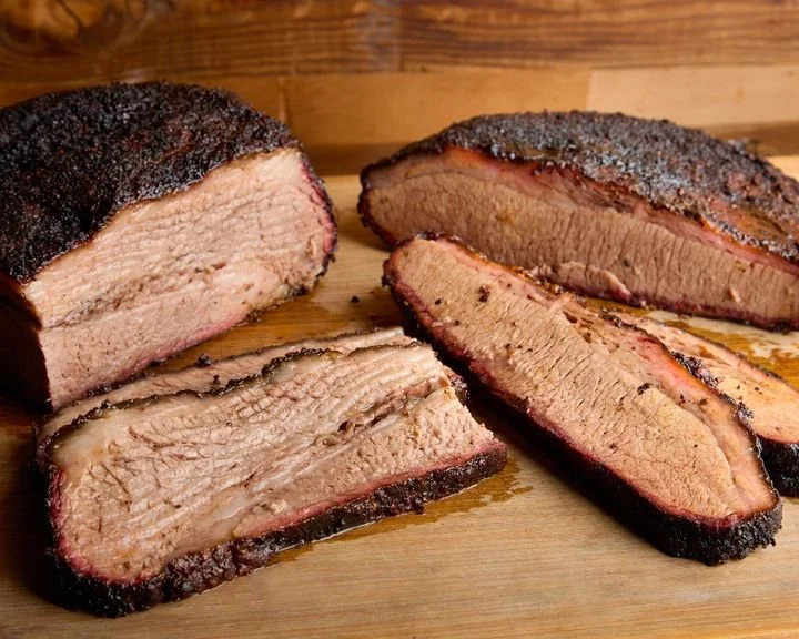 Brandt Family Farms beef brisket on a wood cutting table with wood background