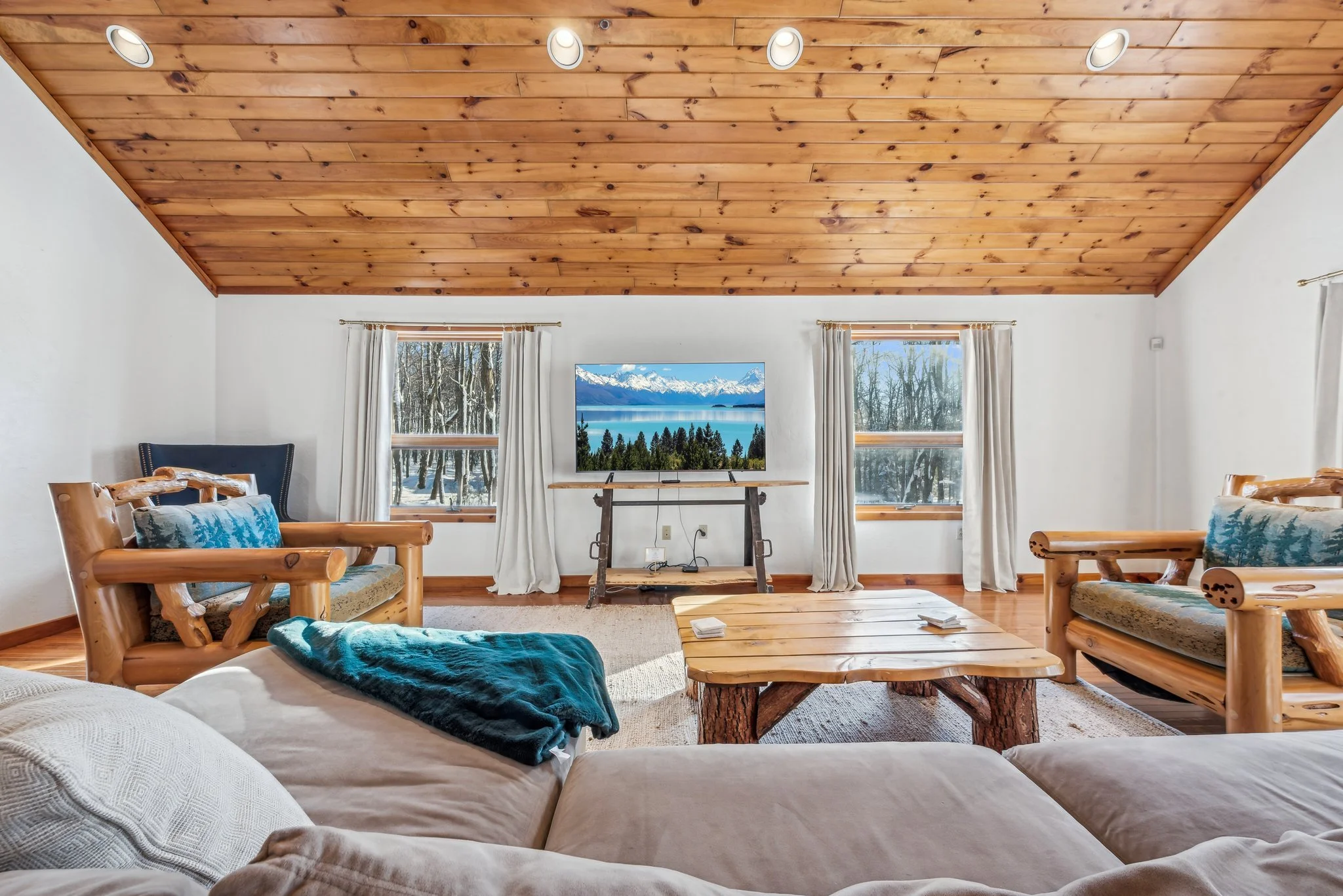 large first floor primary suite with large private living room with wooded views