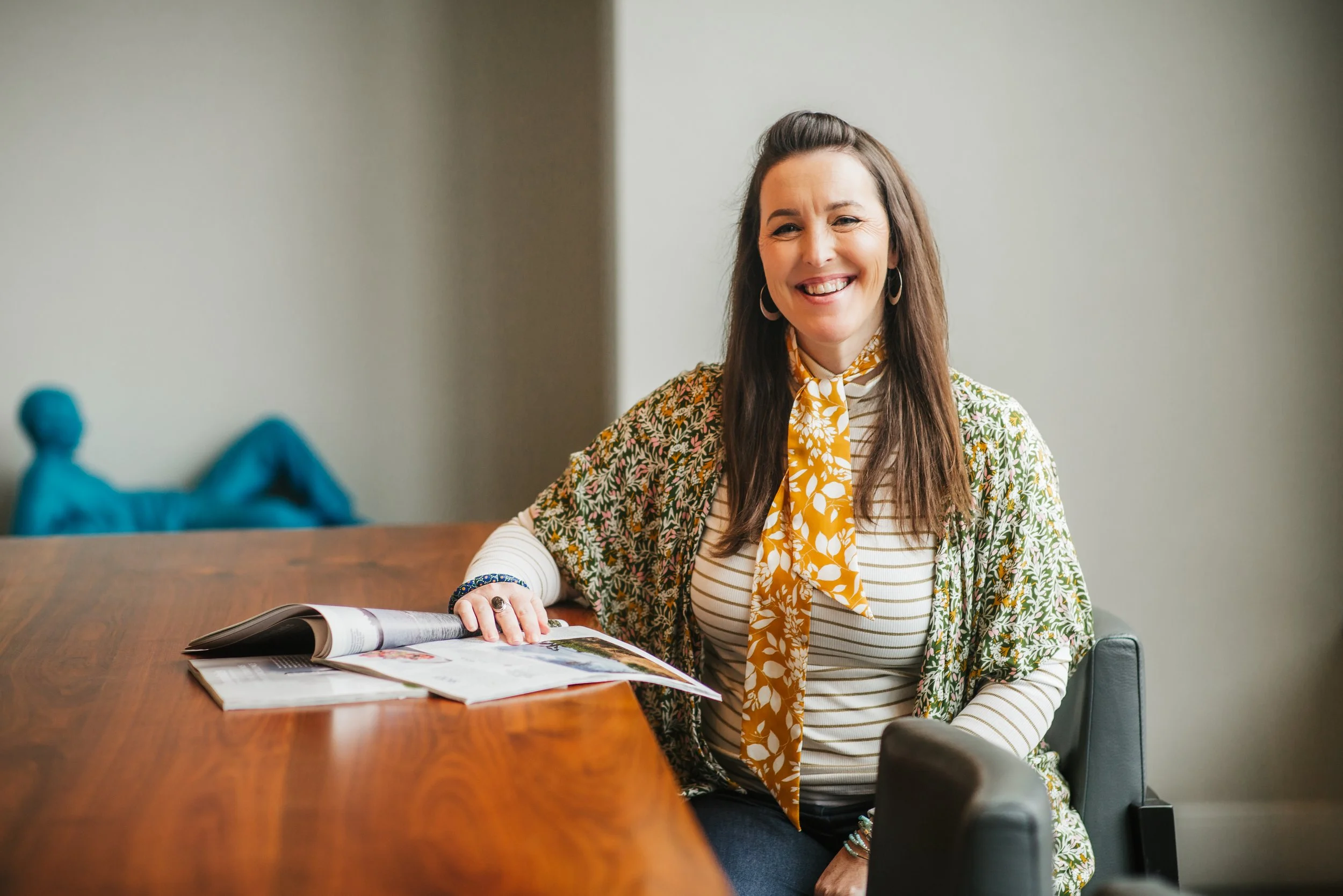 Katie Babcock sitting at a table with a magazine open