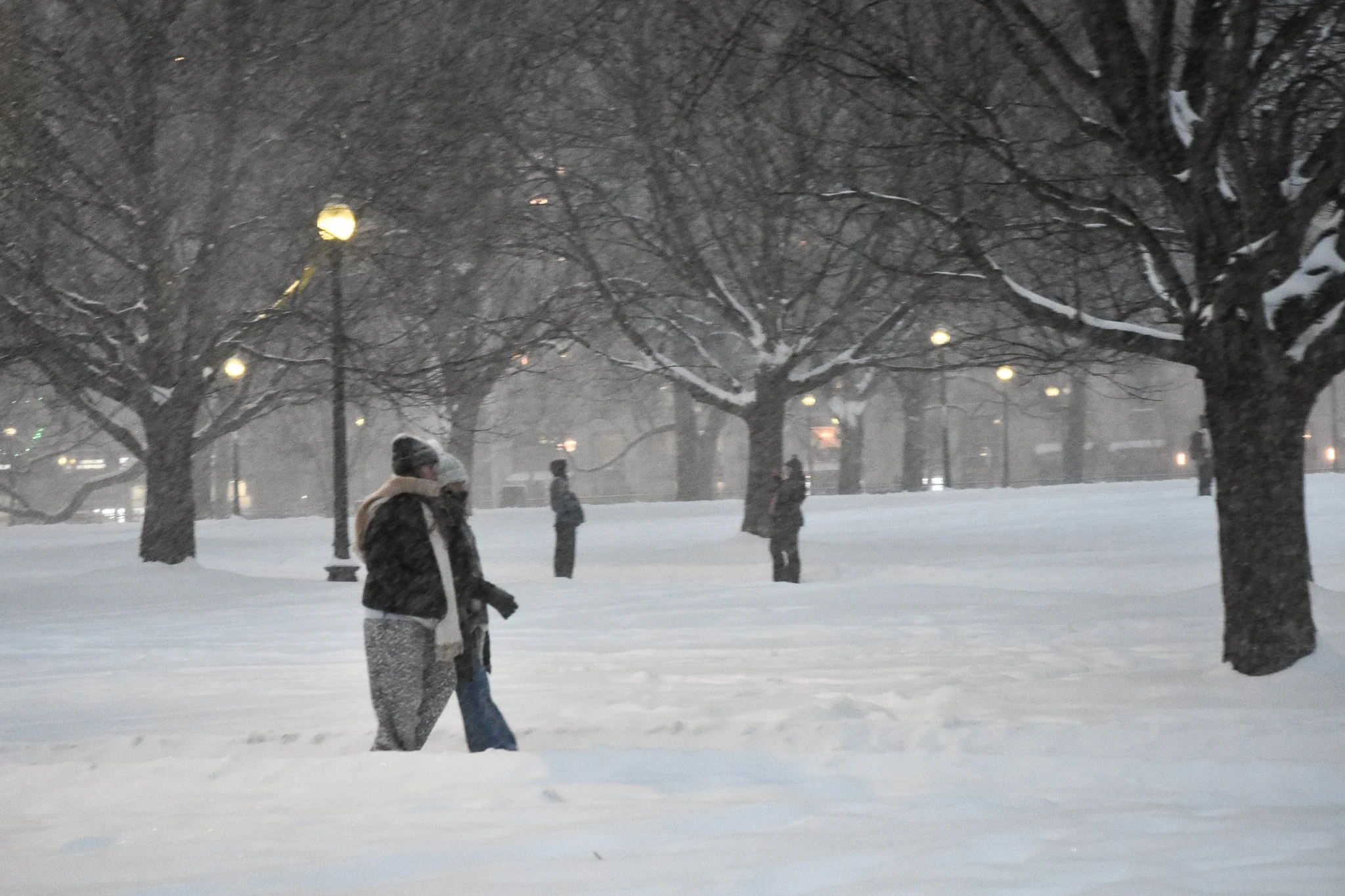 Boston, MA: Jan. 25 -  Two people walk while two others capture the moment. 