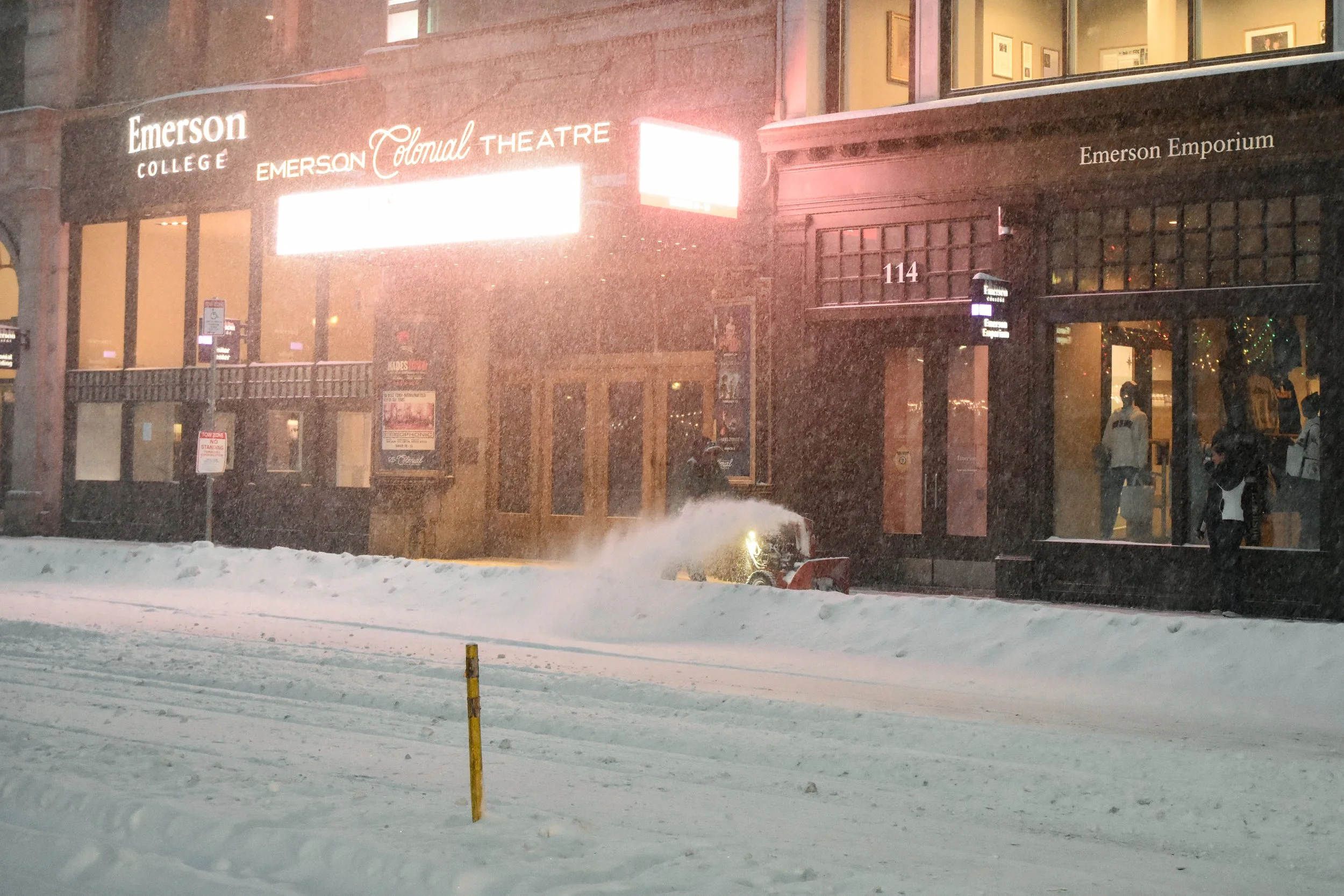 Boston, MA: Jan. 25 -  A person using a snow blower clears the sidewalk by the Emerson Colonial Theatre. 