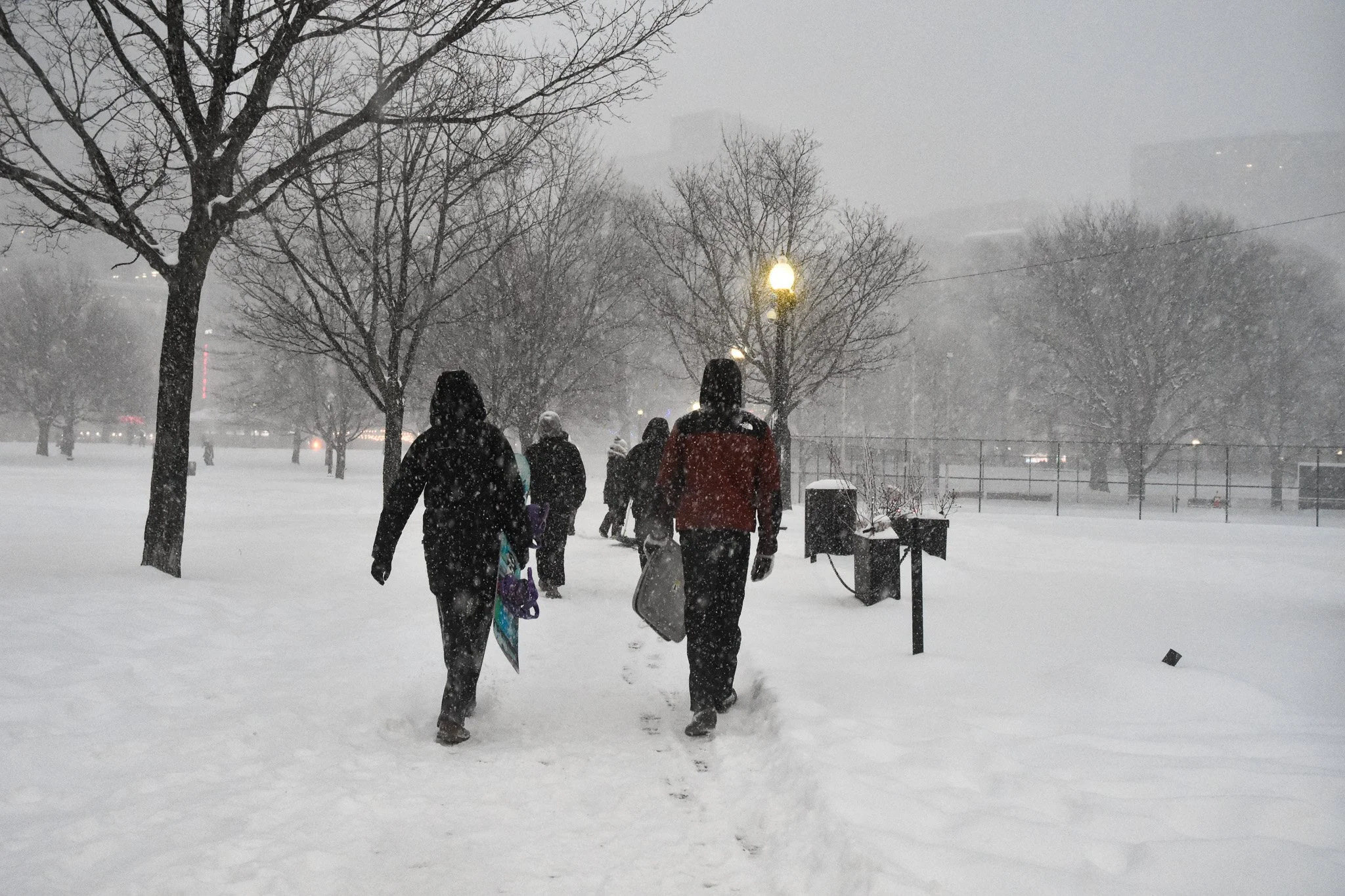 Boston, MA: Jan. 25 -  Two people with very different equipment make their way through the Boston Common. 
