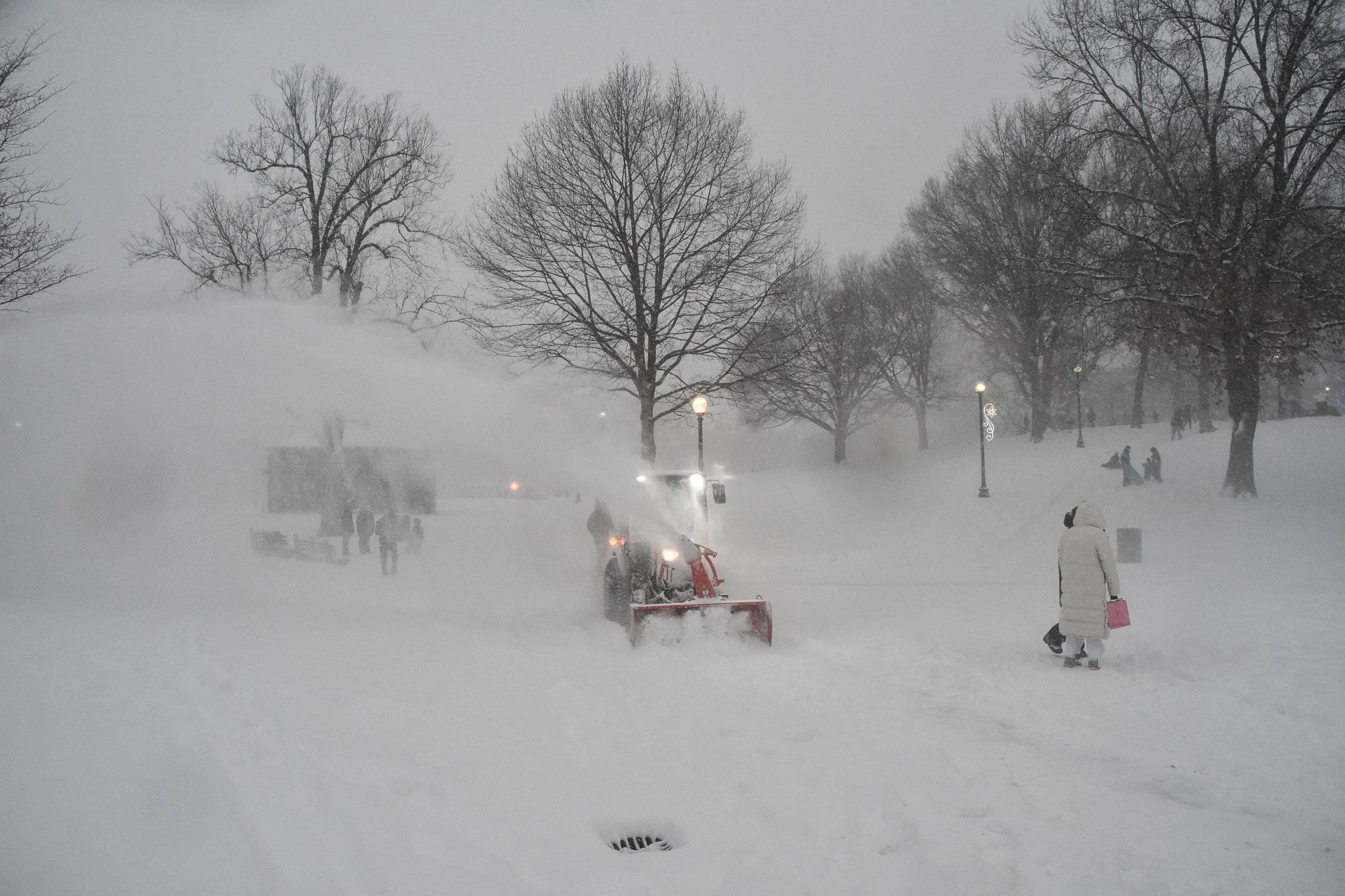 Boston, MA: Jan. 25 -  A snowblower tractor clears snow off the sidewalk in the Boston Common. 