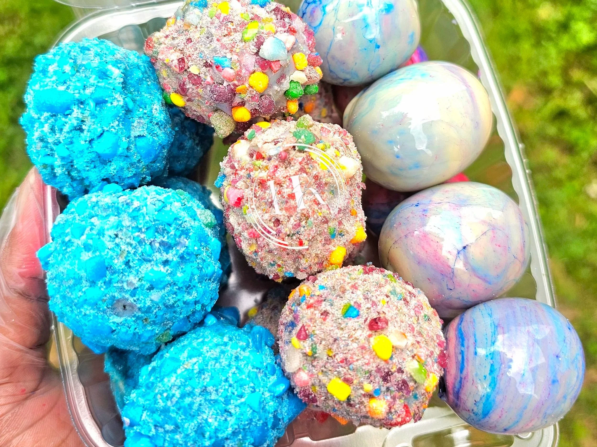 Decorative porch post with a black and brown leopard print pattern, a central black section with white text 'Home Sweet Home' inside a white leaf wreath, topped with a large silver bow and greenery, on a porch with potted plants and a tree in the background.