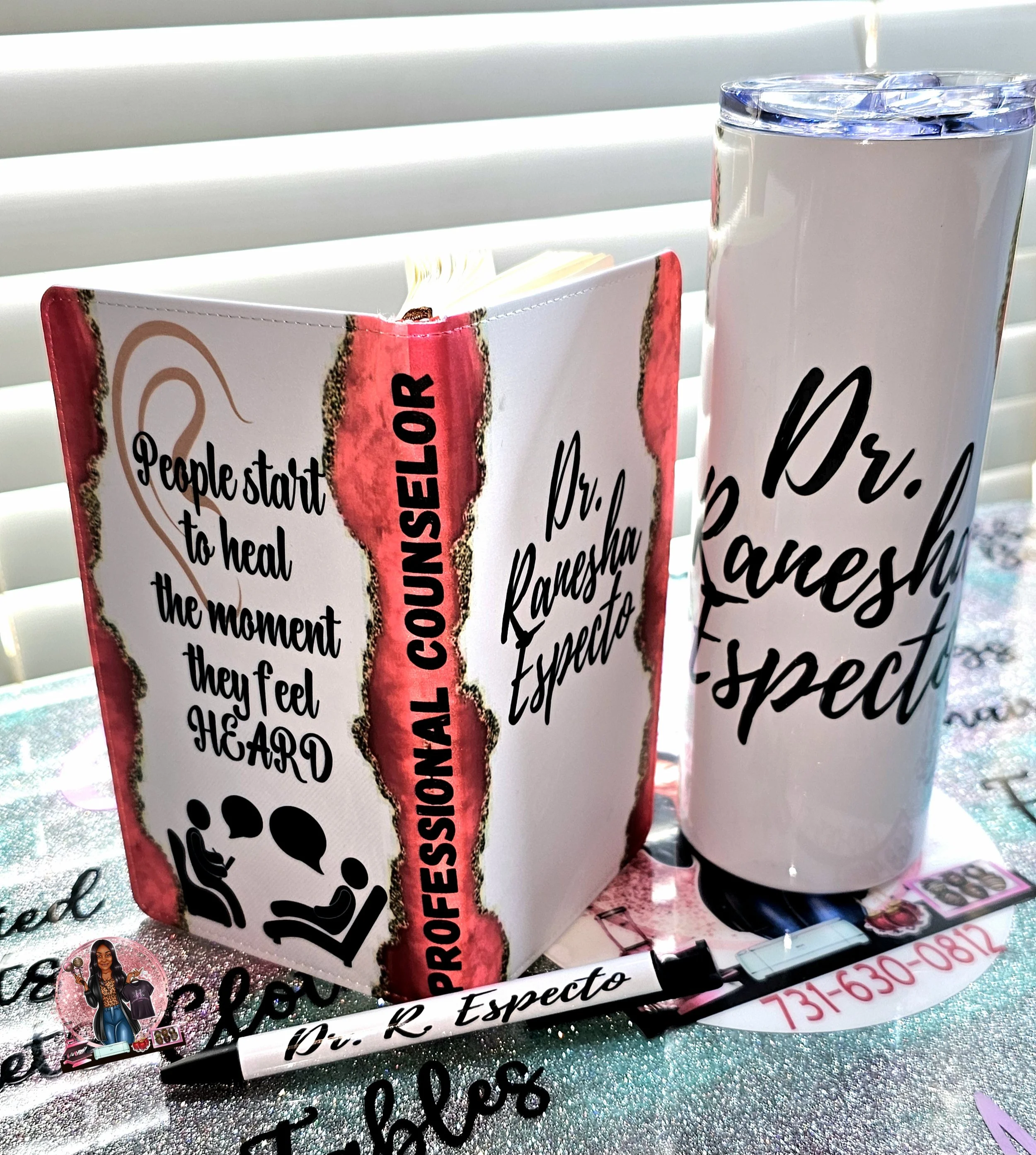 A custom notebook, an ink pen, and a tumbler.