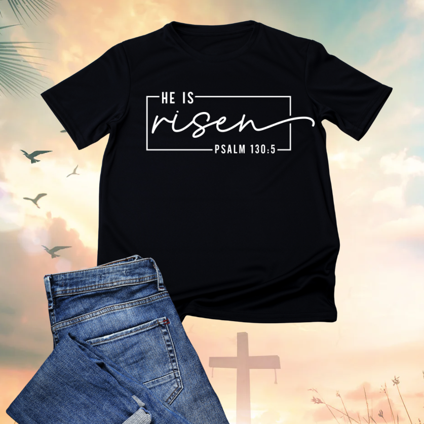 Black t-shirt with the words "He is risen" and a Bible verse reference Psalm 130:5, accompanied by a pair of blue jeans, set against a background with a cross, clouds, birds, and a sunrise or sunset sky.